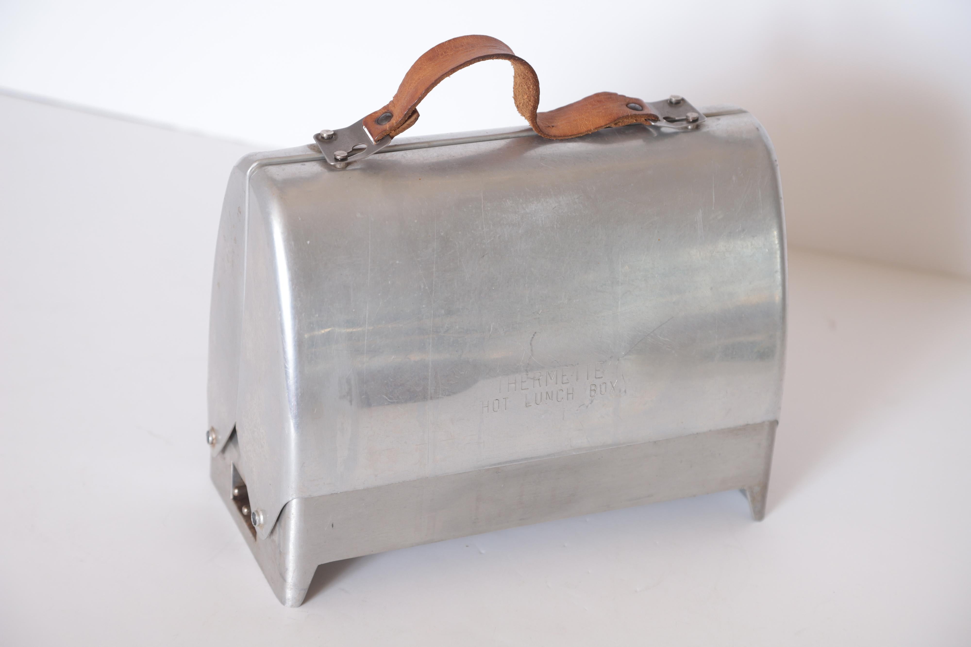 Art Deco Machine Age Industrial Design Thermette Hot Lunch Box by Privett Mfg. Co. Circa 1943  Lunch Pail Lunchpail Lunchbox
American Industrial Design

Thermette hot lunch box from the 1940s.  Polished aluminum.
Leather strap on top for carrying