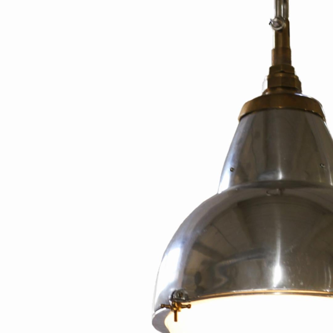 Con su pátina envejecida y su encanto utilitario, estos Colgantes Industriales de la Era de la Máquina Art Decó presentan difusores de aluminio pulido, latón y vidrio esmerilado. Fabricada con detalles de fábrica, presenta una silueta atemporal