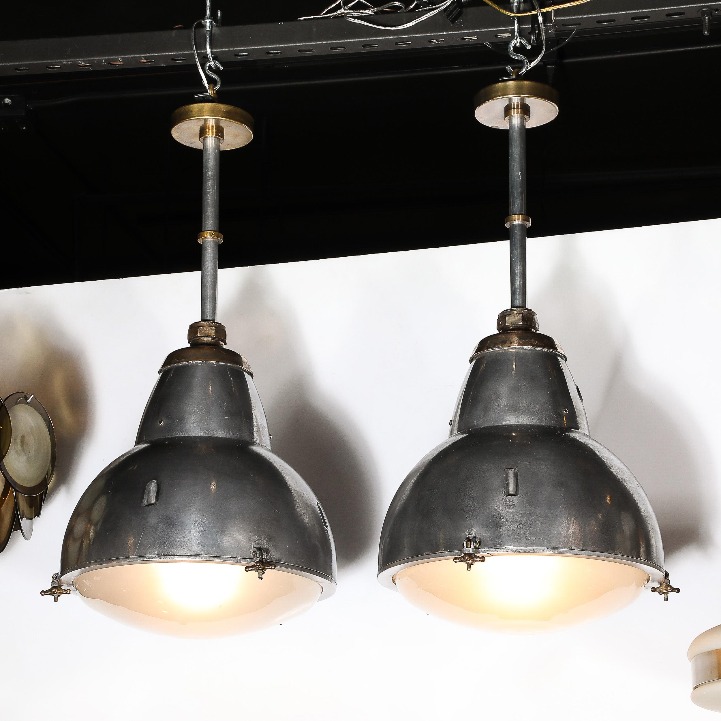 This pair of Art Deco Machine Age industrial pendants, American-made around 1935, embodies the era’s dynamic fusion of form and function. Crafted from polished aluminum, bronze, and brass, they reflect the innovative spirit and futuristic vision of