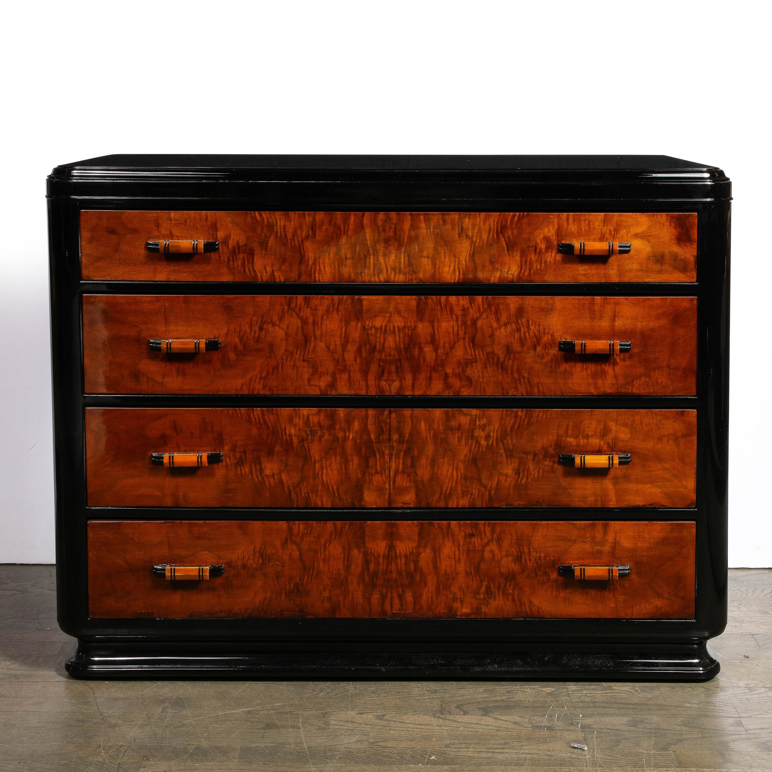 This refined Machine Age Art Deco low chest was realized in America circa 1935. It features a lustrous black lacquer base and body with four drawers in stunning bookmatched burled walnut (showcasing the rich natural figuration of the hardwood in