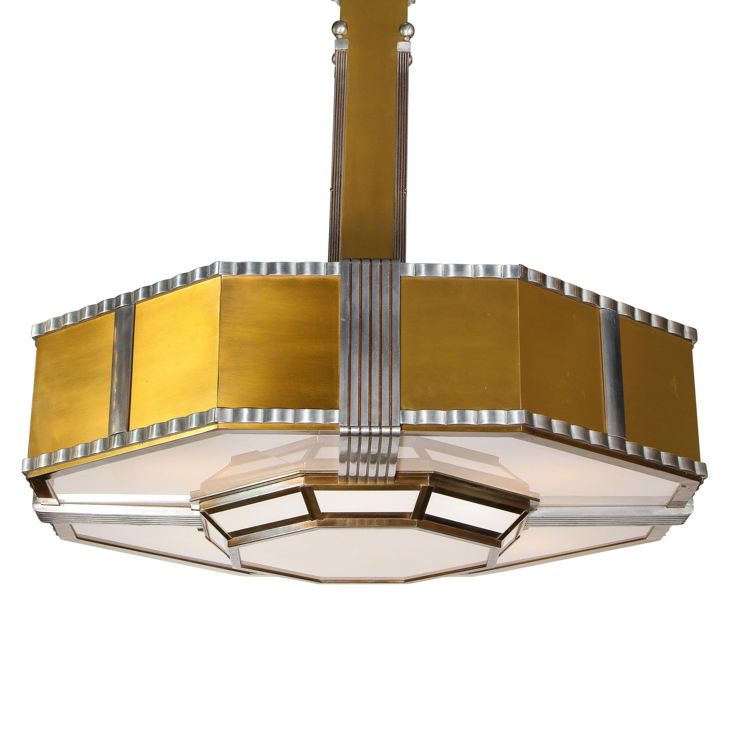 This rare and iconic Art Deco Machine Age skyscraper style chandelier was realized in America, circa 1935. The monumental scale fixture offers a two tier configuration and an octagonal form composed of brushed brass, aluminum and frosted glass. The