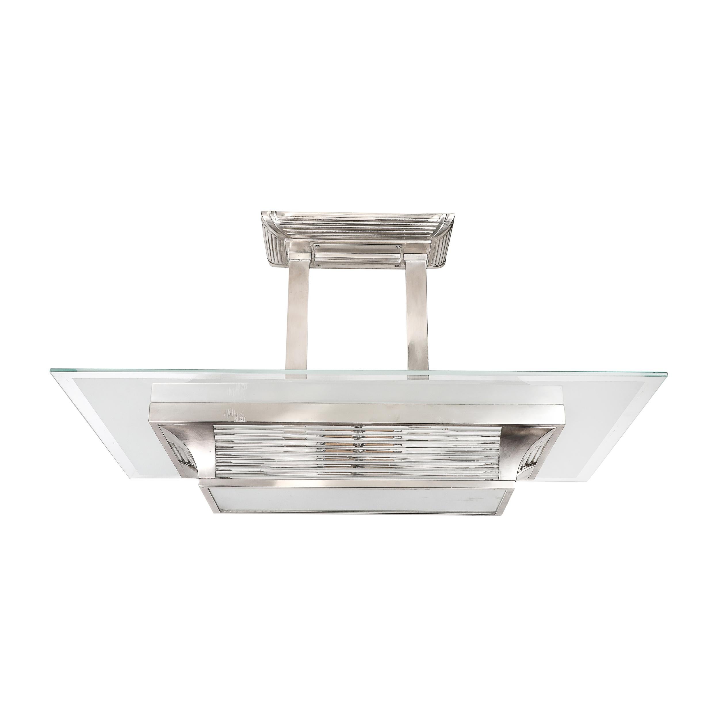 Questo eccezionale lampadario a sospensione rettangolare Art Deco Machine Age, progettato in Francia nel 1935 circa da Petitot, esemplifica il fascino dell'epoca per la precisione geometrica, l'elegante modernità e la meticolosa lavorazione