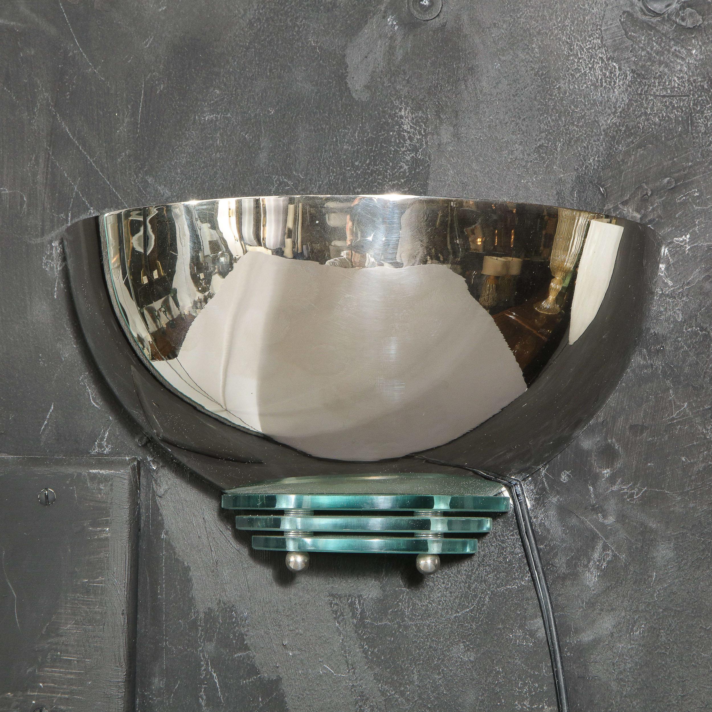 This refined Art Deco Machine Age sconce was realized in the United States circa 1935. It features a streamlined shade in lustrous nickel above three skyscraper style glass tiers secured by spherical nickel finials. With its quintessentially Art