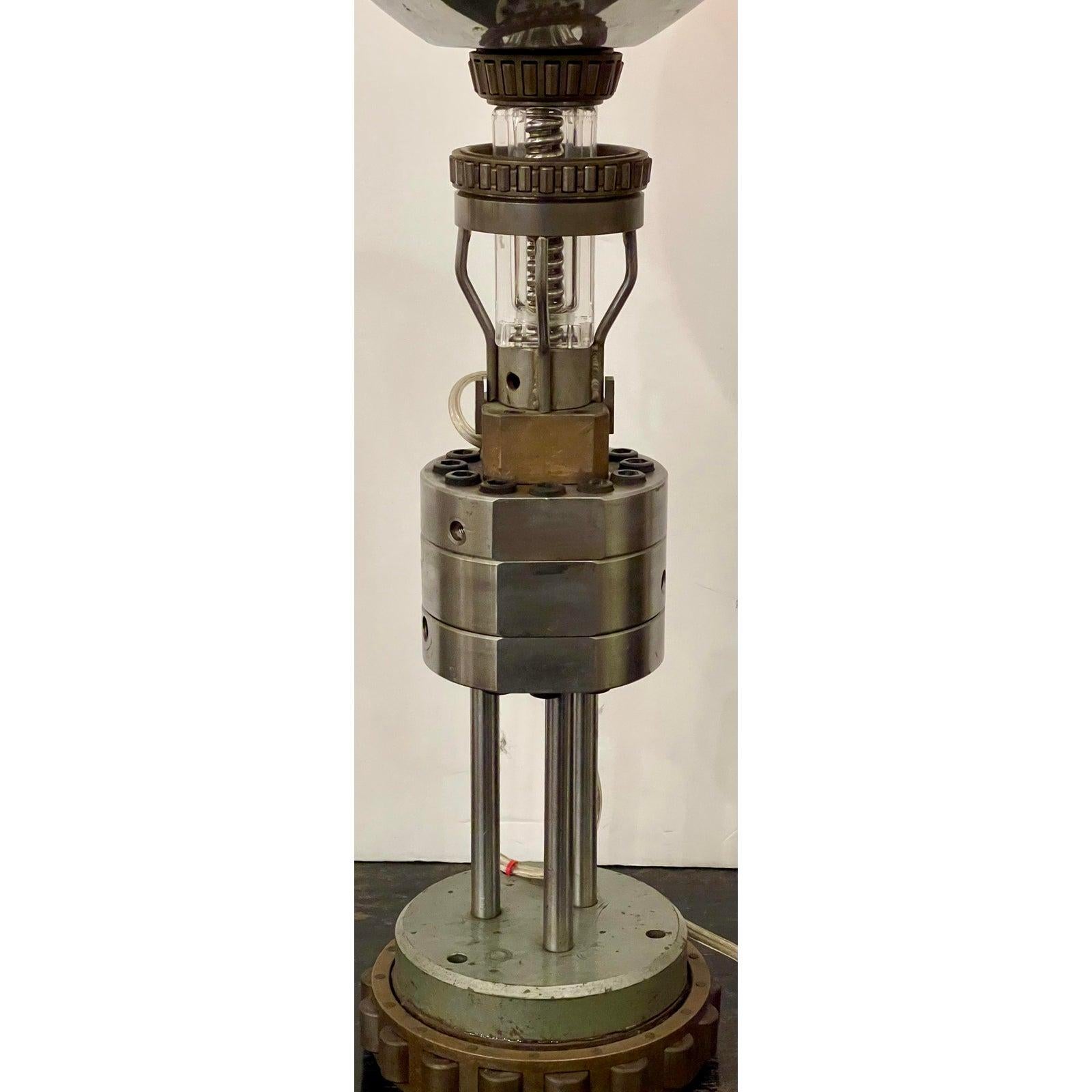 Art Deco machine age steampunk table lamp.

Additional information:
Materials: brass, bronze, lights, steel.
Color: silver.
Period: Early 20th century.
Styles: Art Deco, Mid-Century Modern.
Lamp Shade: included. 
Power Sources: Up to 120V