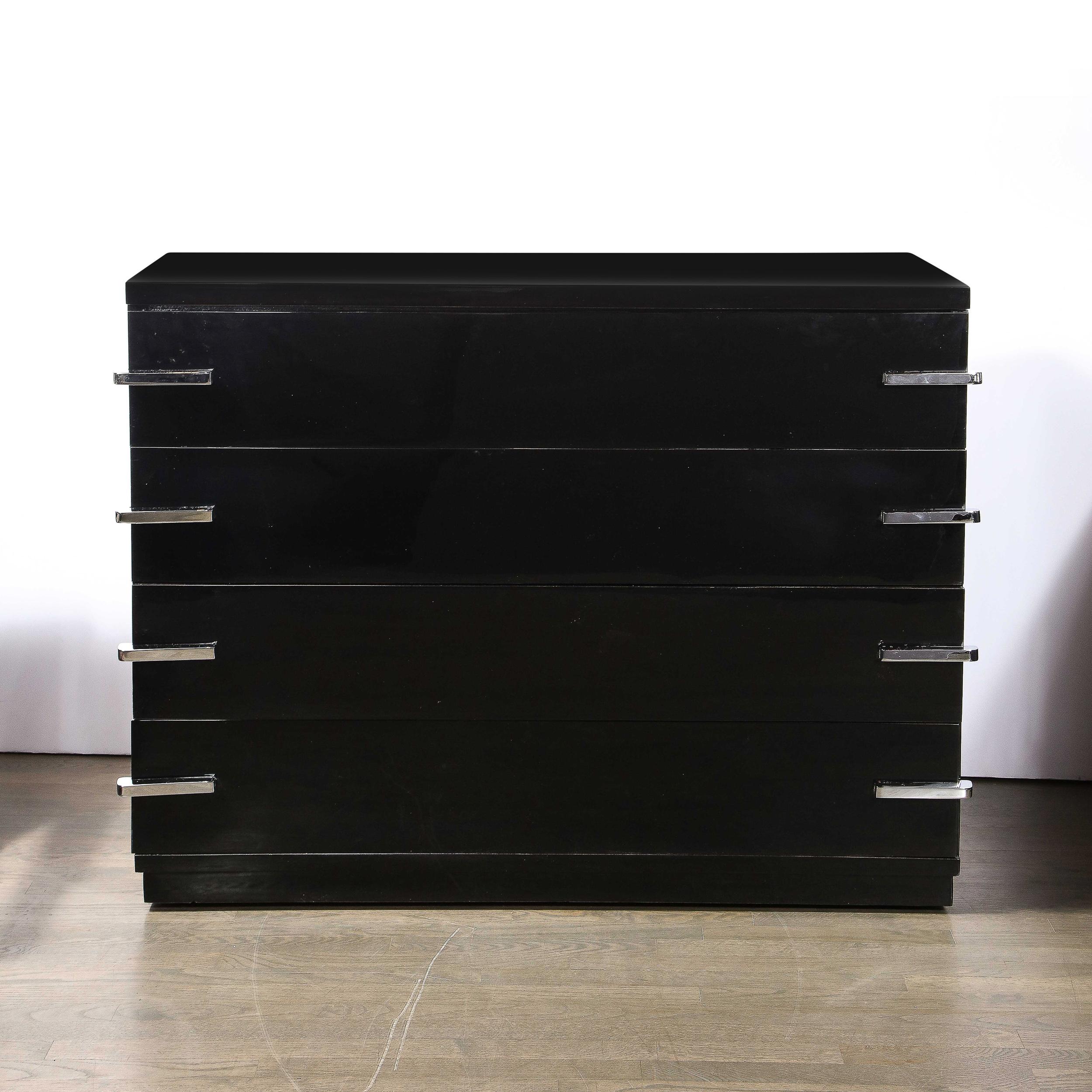 This stunning Art Deco Machine Age black lacquer four drawer wide dresser was realized in the United States, circa 1935. It offers a tiered skyscraper style base and volumetric rectangular body in lustrous black lacquer. Each drawer is fitted with