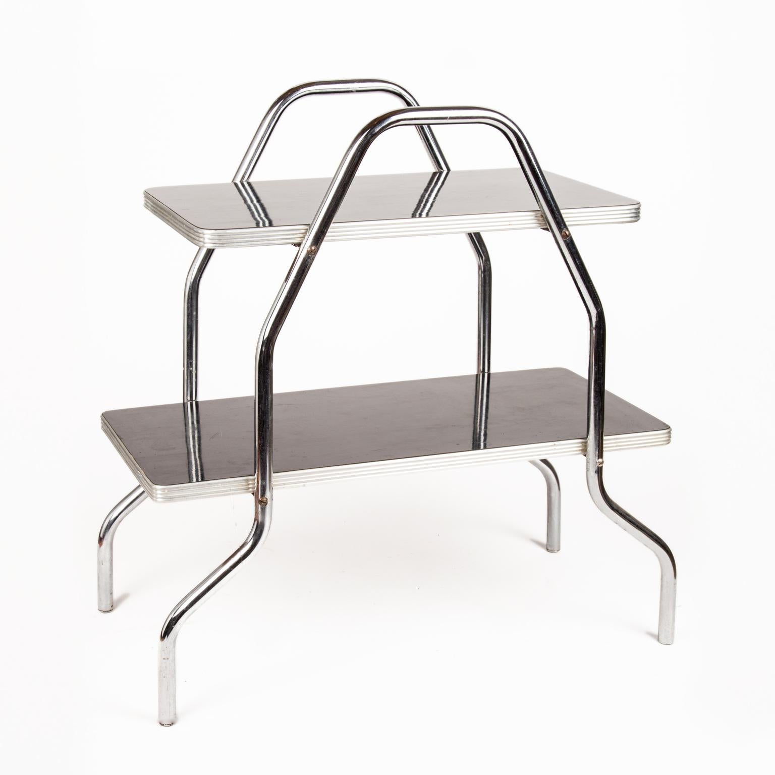 Art Deco Machine Age black and chrome angular table after Wolfgang Hoffmann, Gilbert Rohde or Donald Deskey. The top is smaller and graduates to a larger size on the second tier, circa 1940s.