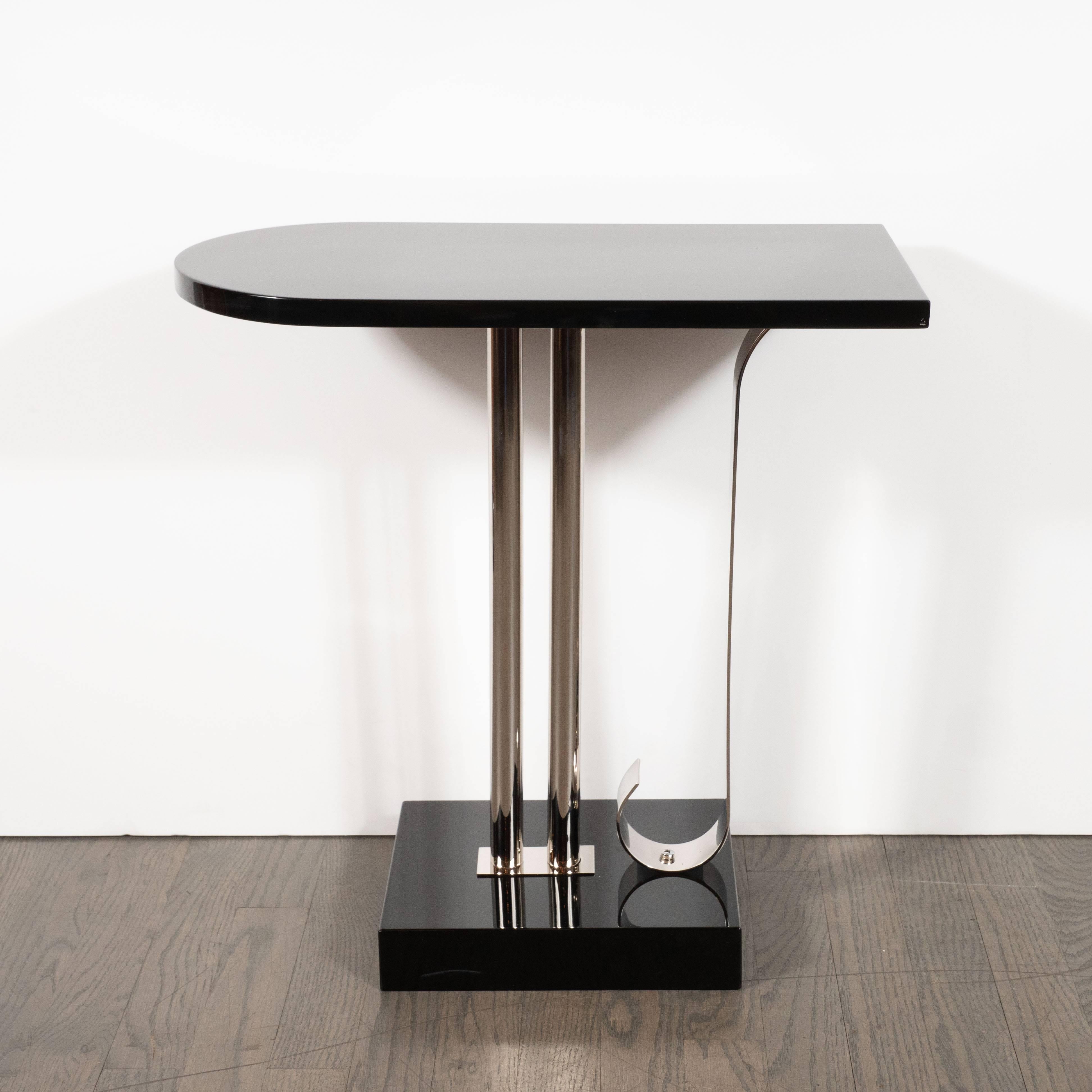 This sleek and sophisticated drinks or side table was realized in the United States by the esteemed maker, Belmet Products, circa 1935. Its top- executed in lustrous black lacquer- offers a streamlined form suggestive of a bullet, indicative of the