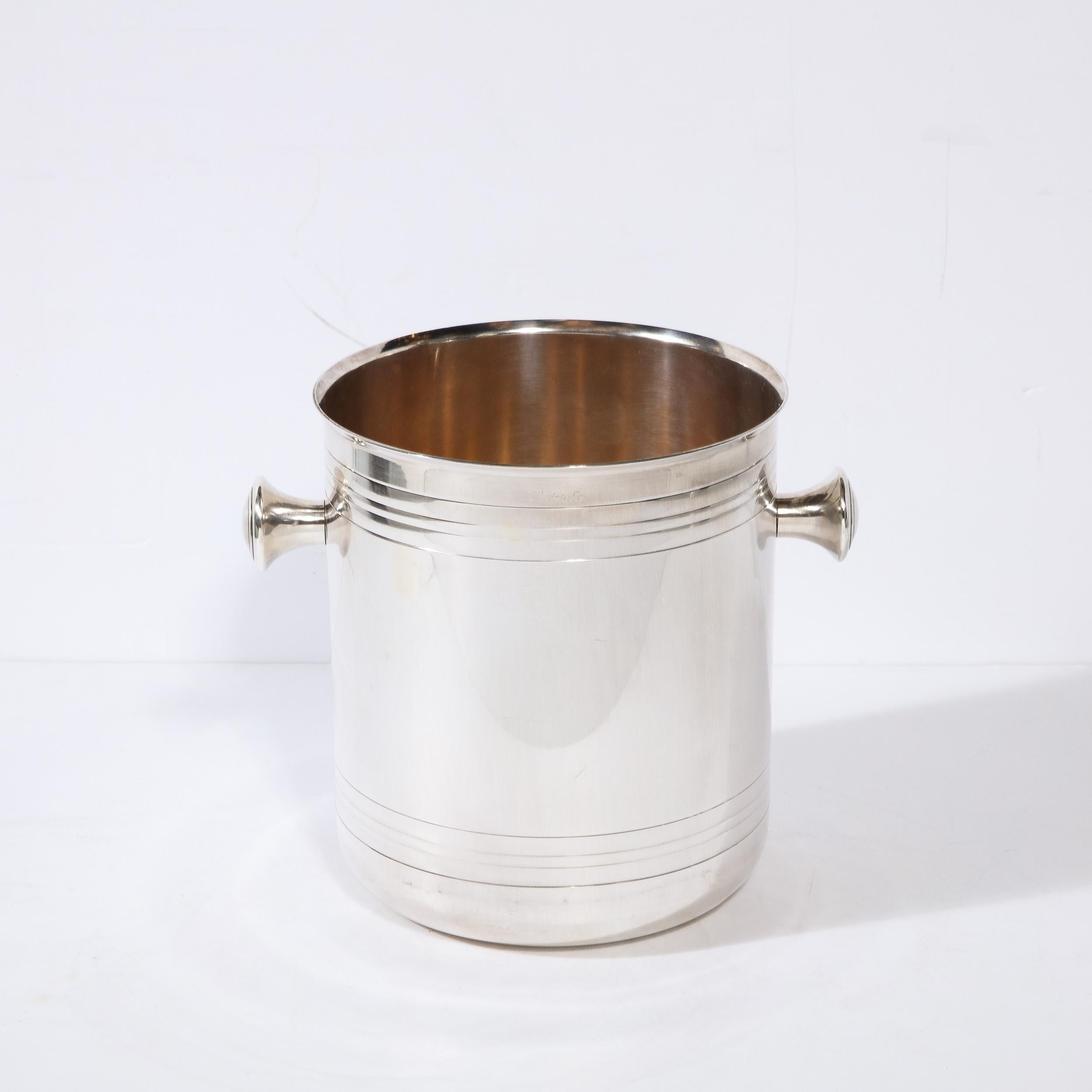 This lovely Art Deco Style Machine Age Style Christofle Silver Plate Ice/Champagne Bucket originates from France during the latter half of the 20th Century. Features machine age knob form handles on either side beneath subtle rings of linear banded
