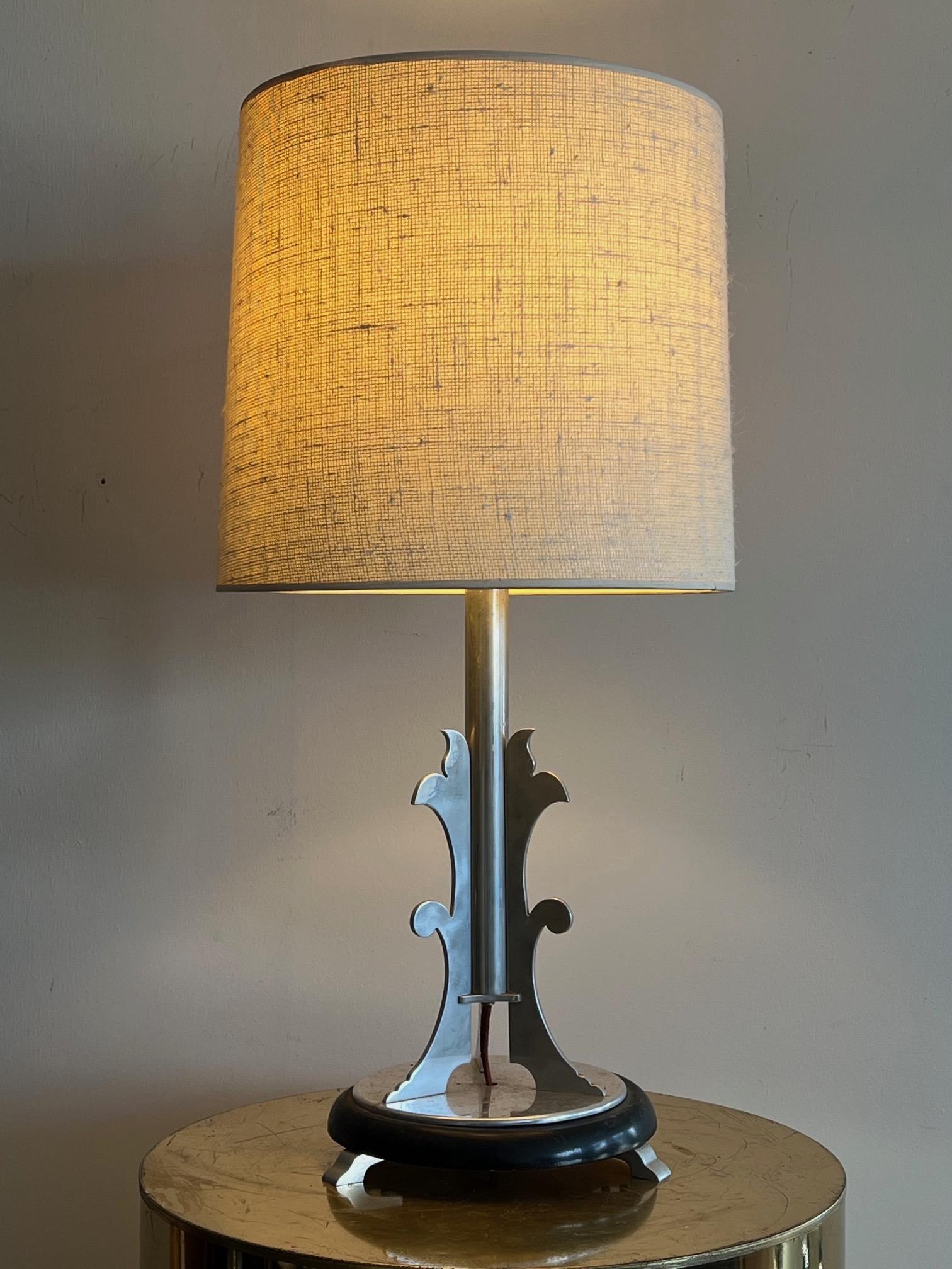 An unusual Machine Age/Art Deco table lamp. Polished aluminum, on a raised base. Original copper lined socket.