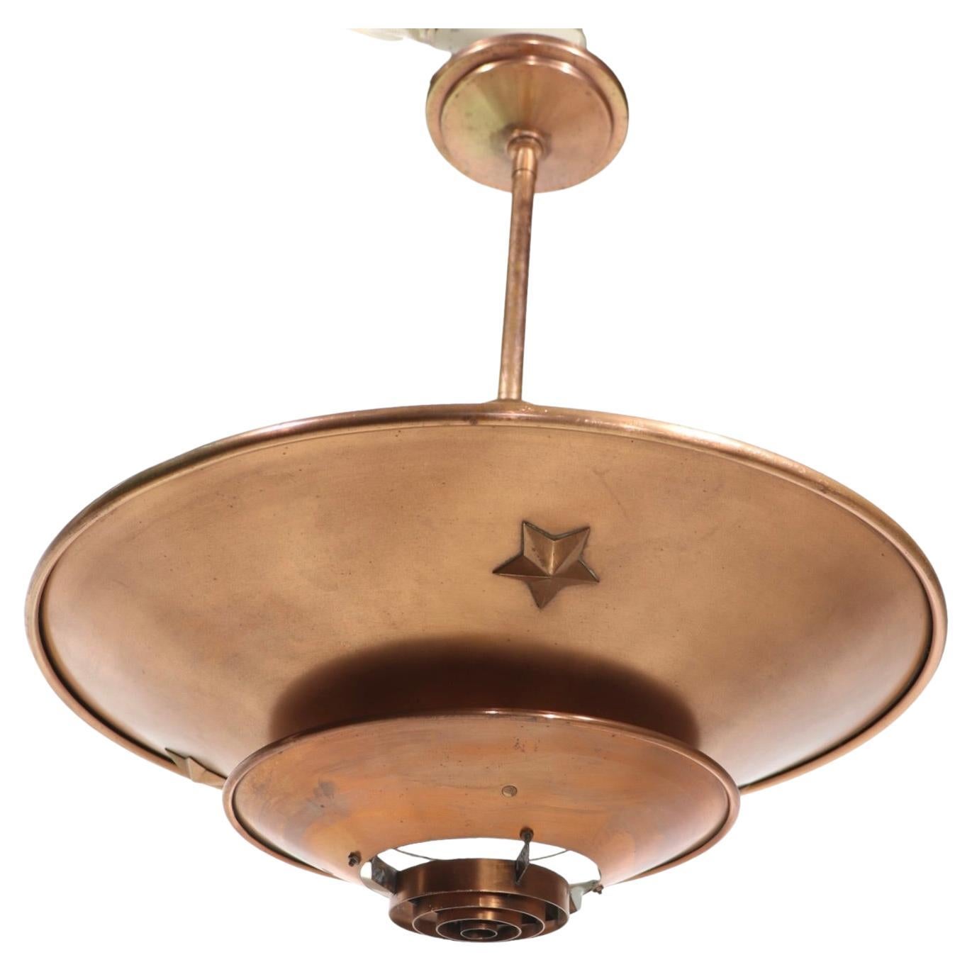 Chic, architectural and sophisticated saucer form chandelier, Art Deco, Machine Age style circa  1930’s. 
The fixture features three graduated disk form rings, the smallest ring at the center bottom is constructed of concentric rings, to allow more