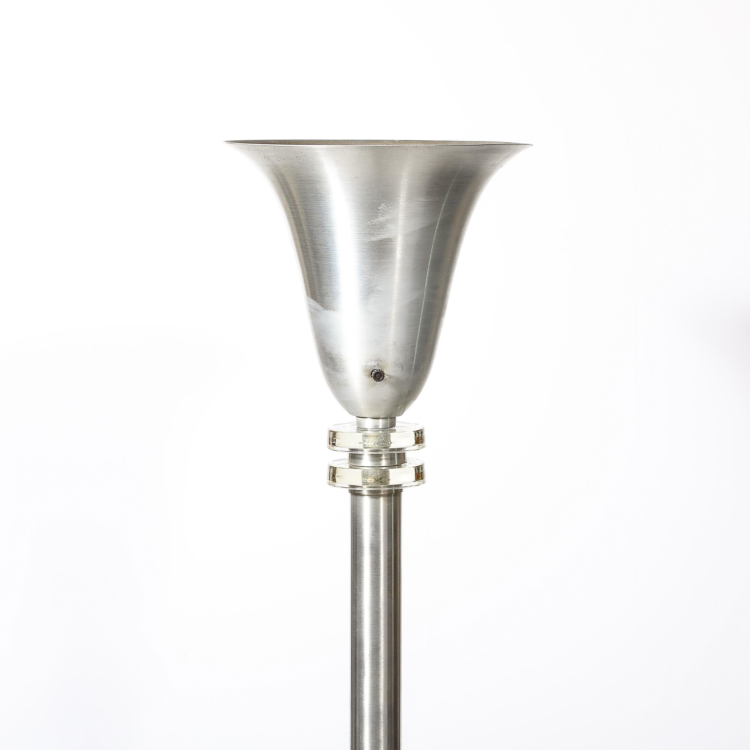 Cette torchère Art déco de l'âge des machines, signée par le célèbre designer industriel américain Russel Wright, est une pièce étonnante datant d'environ 1940. La torchère présente un mélange sophistiqué d'aluminium brossé et de verre, mettant en