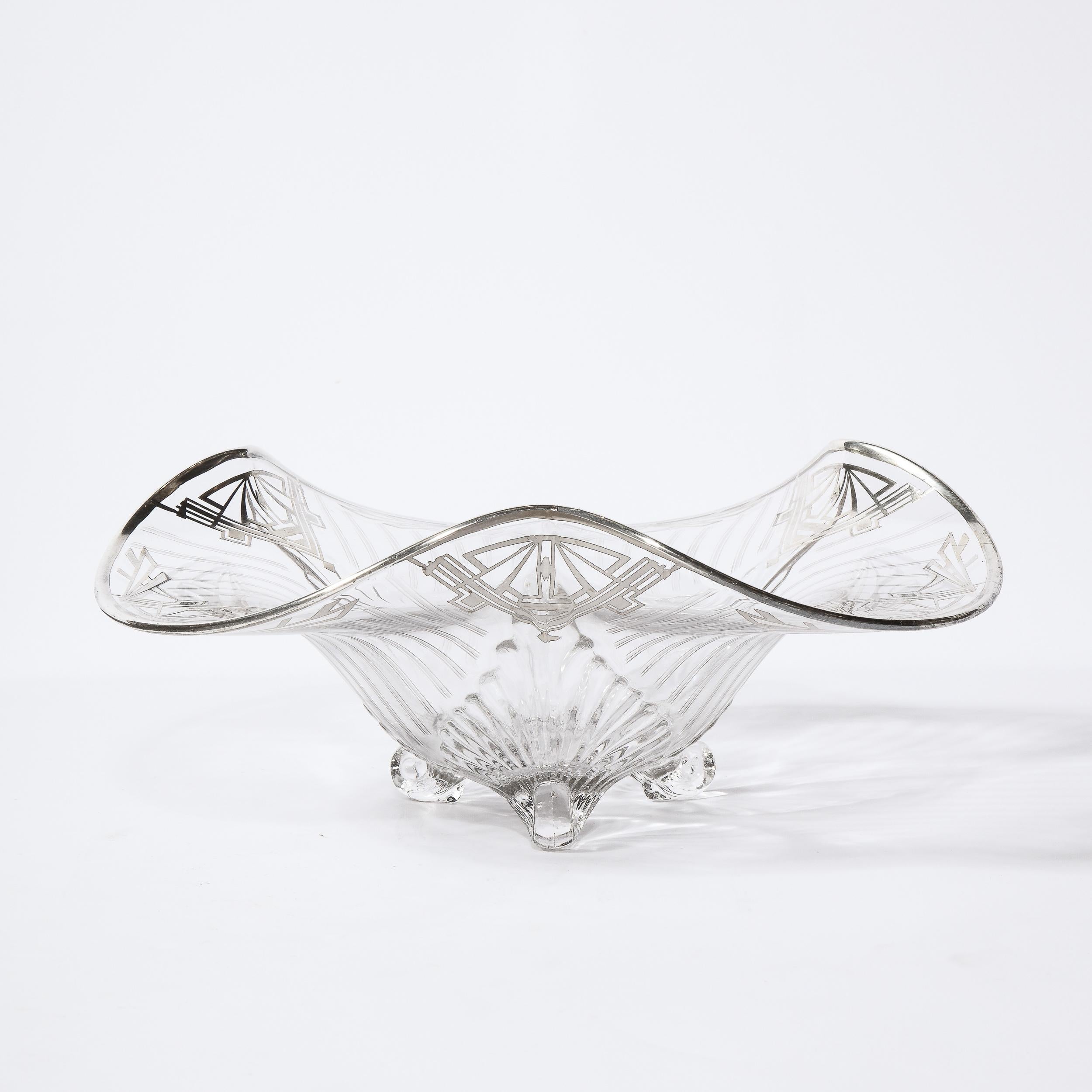 Questa splendida ciotola centrale Art Deco Machine Age è stata realizzata negli Stati Uniti intorno al 1935. Presenta piedini scultorei a forma di voluta traslucida, un piano ondulato e curvo bordato in argento sterling e dettagli geometrici