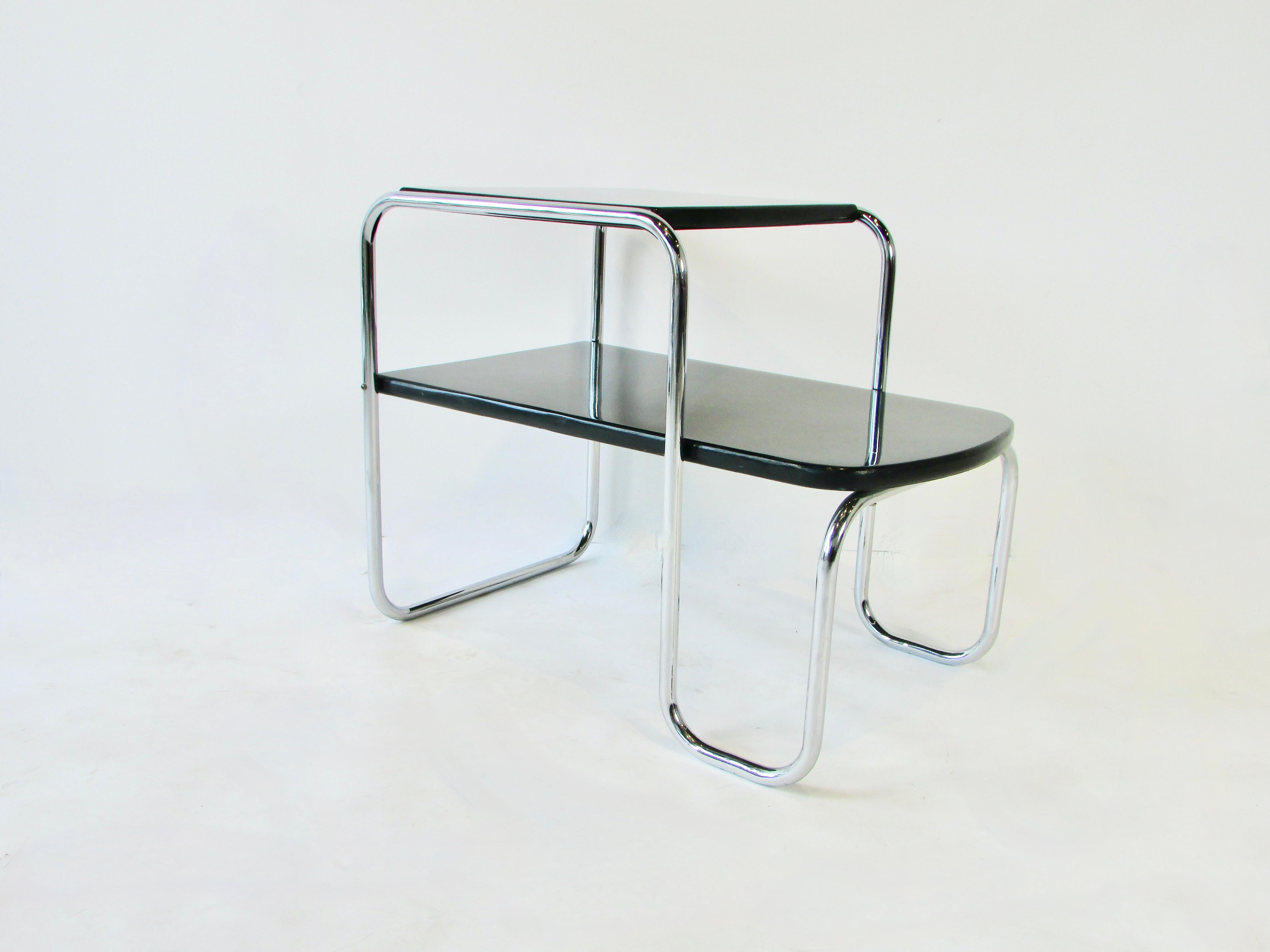 Single piece of chrome tubular steel undulates from floor to top of lacquered table top. Follows down to form second stepped tier. Not labels or evidence of mfr. possibly Howell or Lloyd. Very much in the style of Gilbert Rohde or Donald Deskey.