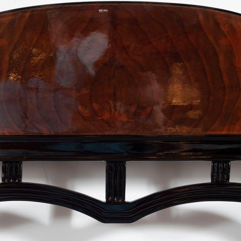 This elegant Art Deco Machine Age vanity chair/ bench was realized in the United States, circa 1935. It features a streamlined back in walnut supported by a black lacquer frame that offers streamlined forms recurring beneath. Additionally, the piece