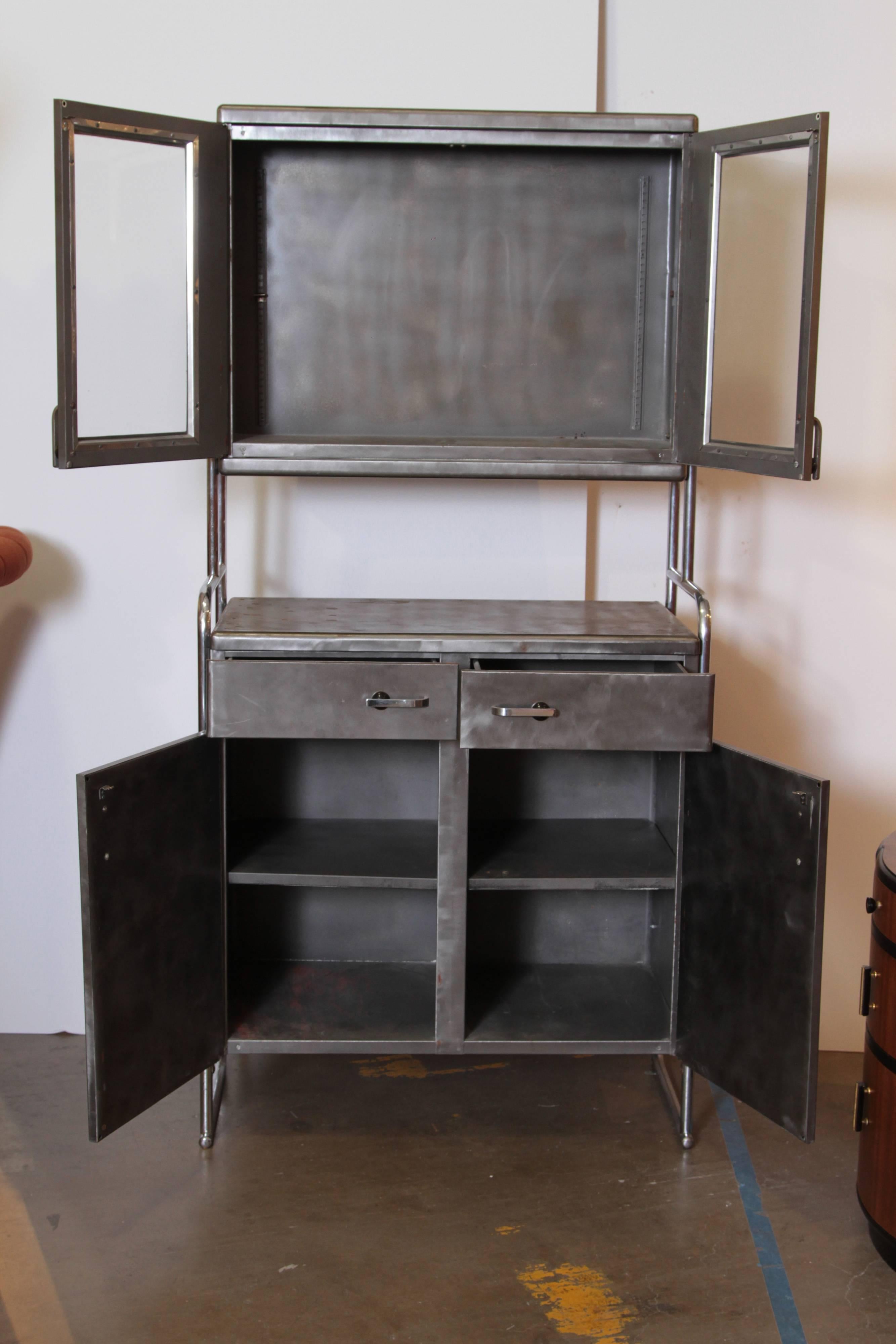 Art Deco Machine Age Wolfgang Hoffmann attribution, rare cabinet by Howell. Hoffman.

Unseen in market: Rare medical / Industrial dual - cabinet tall - boy storage / display unit.
Cases stripped to bare steel at some point.

In our opinion;