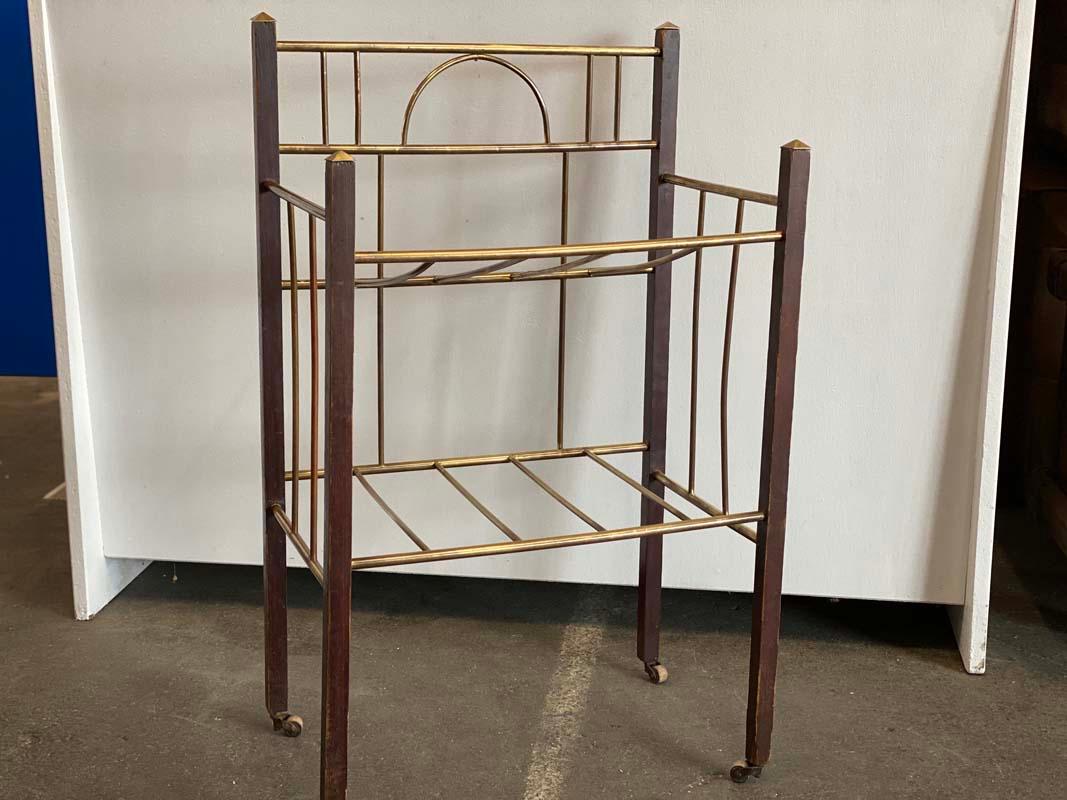 Art Deco newspaper rack from the 1920s. This newspaper rack impresses with its delicate and filigree appearance. The geometric design is stylistically typical of the Art Deco era. Worked is the small rolling newspaper carrier of fine brass rods,