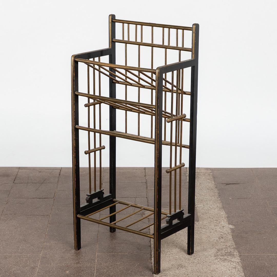 Beautiful and elegant Art Deco magazine rack /shelf from Germany, 1920s. The Magazine rack has a construction made of black-colored wood and four shelfs / storage compartments made of brass. The three top shelves are all in an inclined position. No