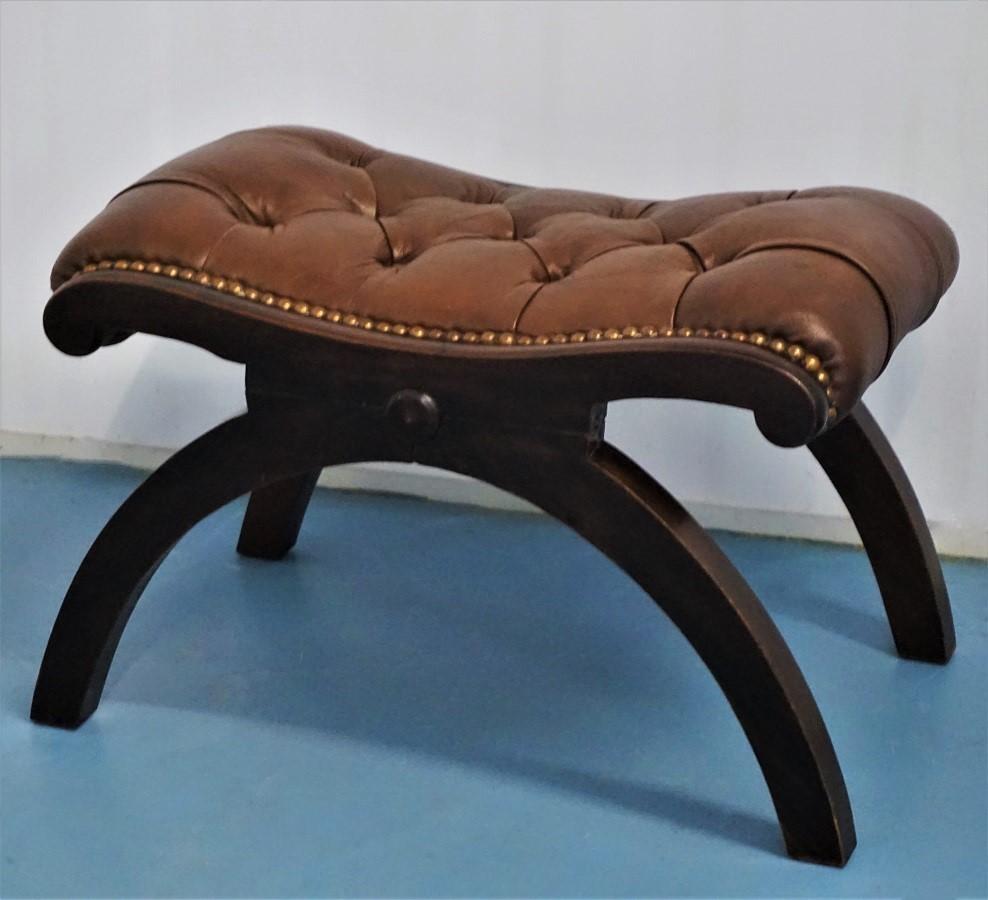 Art Deco leather and mahogany stool, France, 1930s. Deep buttoned brown leather closed with hand-hammered brass studs.
Dimensions: Height 13 inch, width 20 inch, depth 14.235 inch (33 cm x 50 cm x 36).


       
