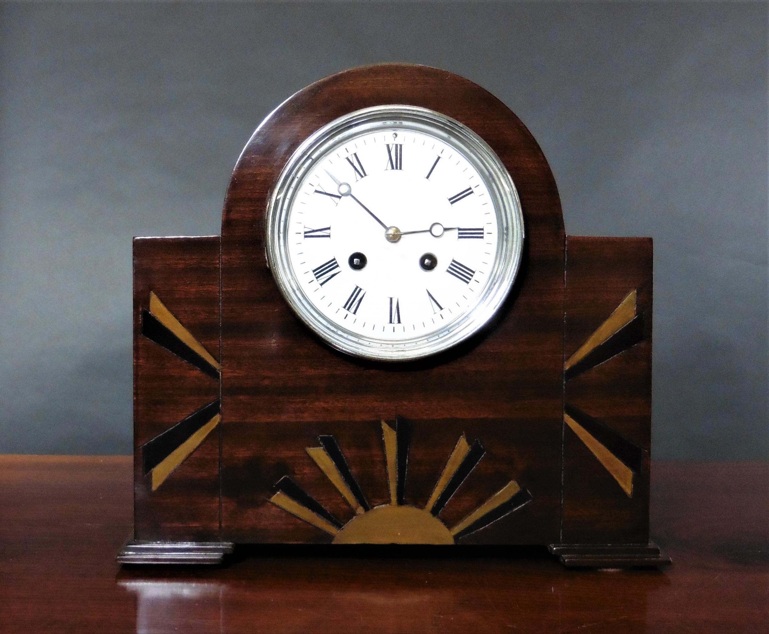 Art Deco Mahogany Mantel Clock



Art Deco mahogany mantel clock housed in a break arch case with geometric fan inlay standing on block feet.

Chrome bezel opening to an enamel dial with Roman numerals and original ‘blued’ steel