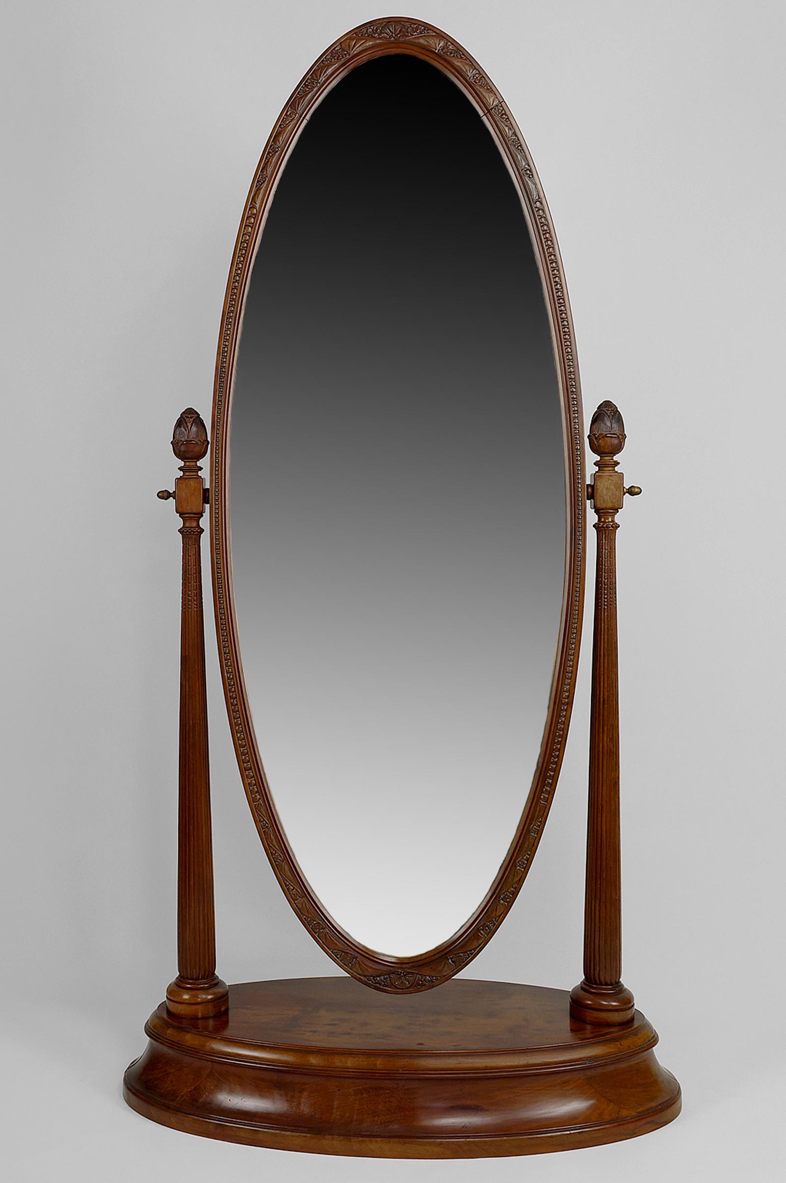 Gorgeous mahogany psyche divided into three parts:

- a large beveled oval mirror and its solid wood frame sculpted with flowers and rows of pearls;

- two fluted uprights / pilasters ending in stylized flowers (à la MacIntosch?);

- an oval