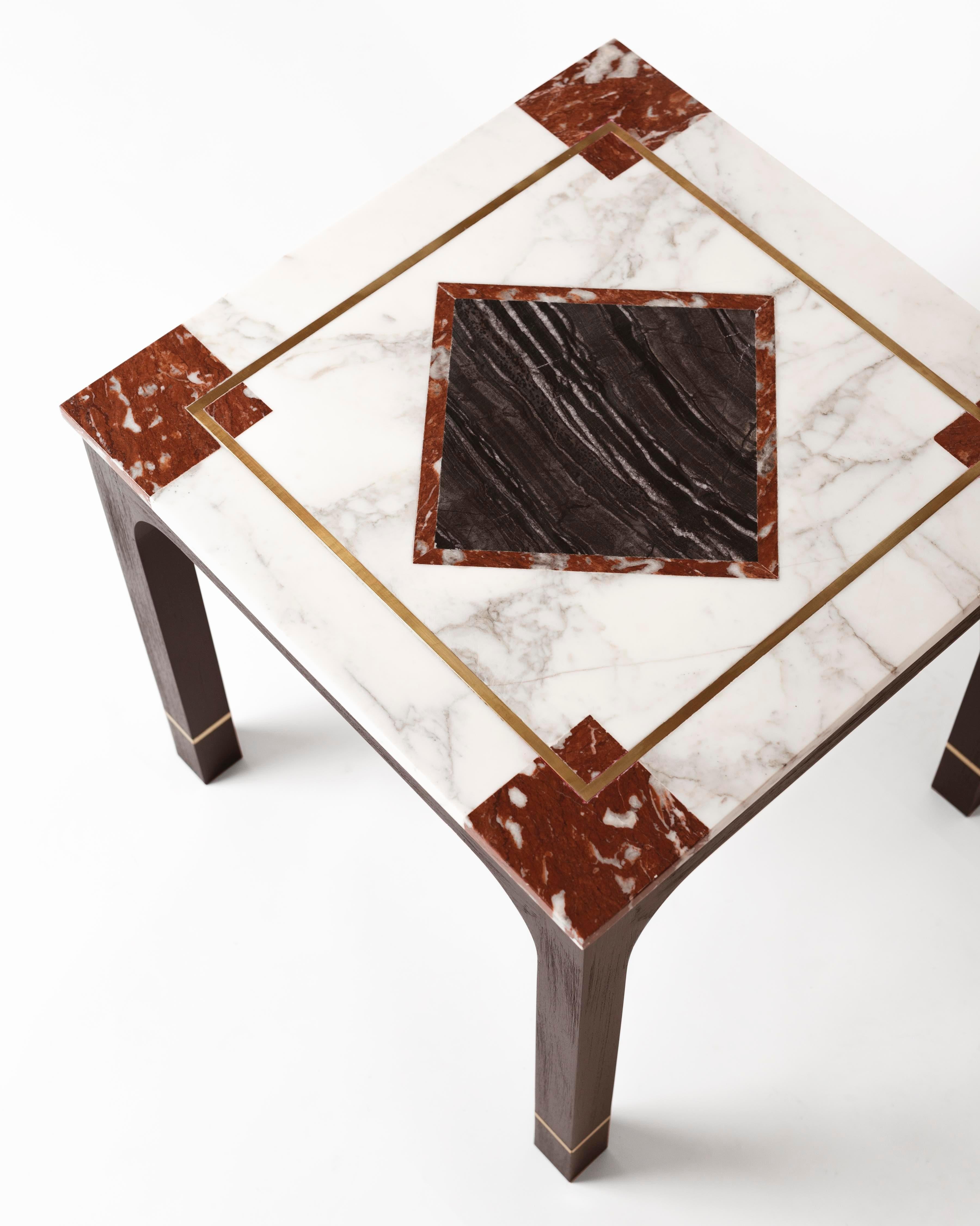 This beautiful mahogany wood side table comes with brass inlays on the legs and has a marble cover built with different combinations of marble and brass trimmings.
The table reveals a strong geometrical presence with combinations of materials that