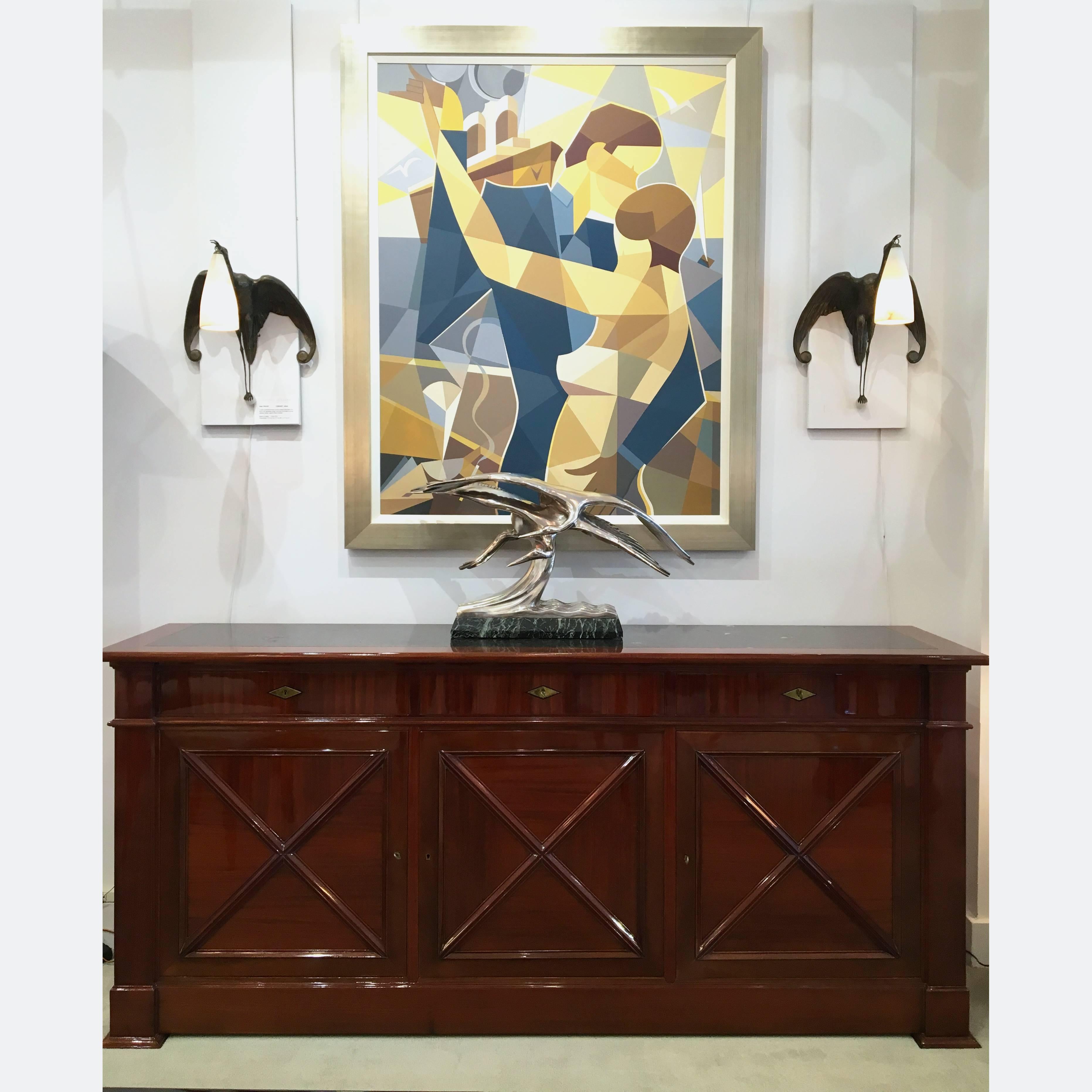 A mahogany sideboard by Maxime Old with a black marble top and details in brass. The sideboard has three drawers and three doors with interior shelves for storage.
Made in France,
circa 1940.
 