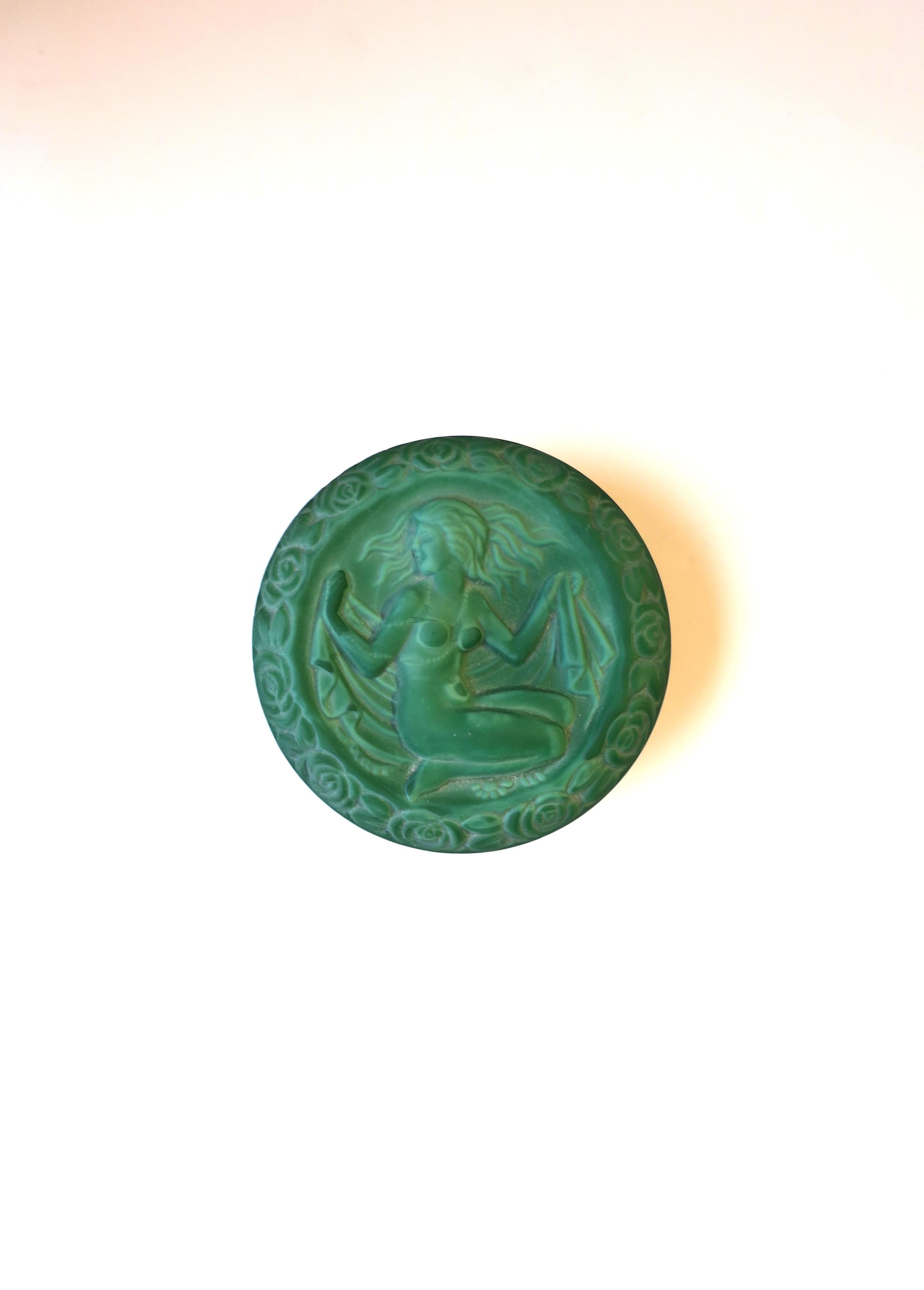 A beautiful hand-made green malachite glass box with female relief in the Art Deco style, circa late-20th century Czech Republic. This is a round box with a high relief of a female nude surrounded by flowers (around edge.) A beautiful box to hold