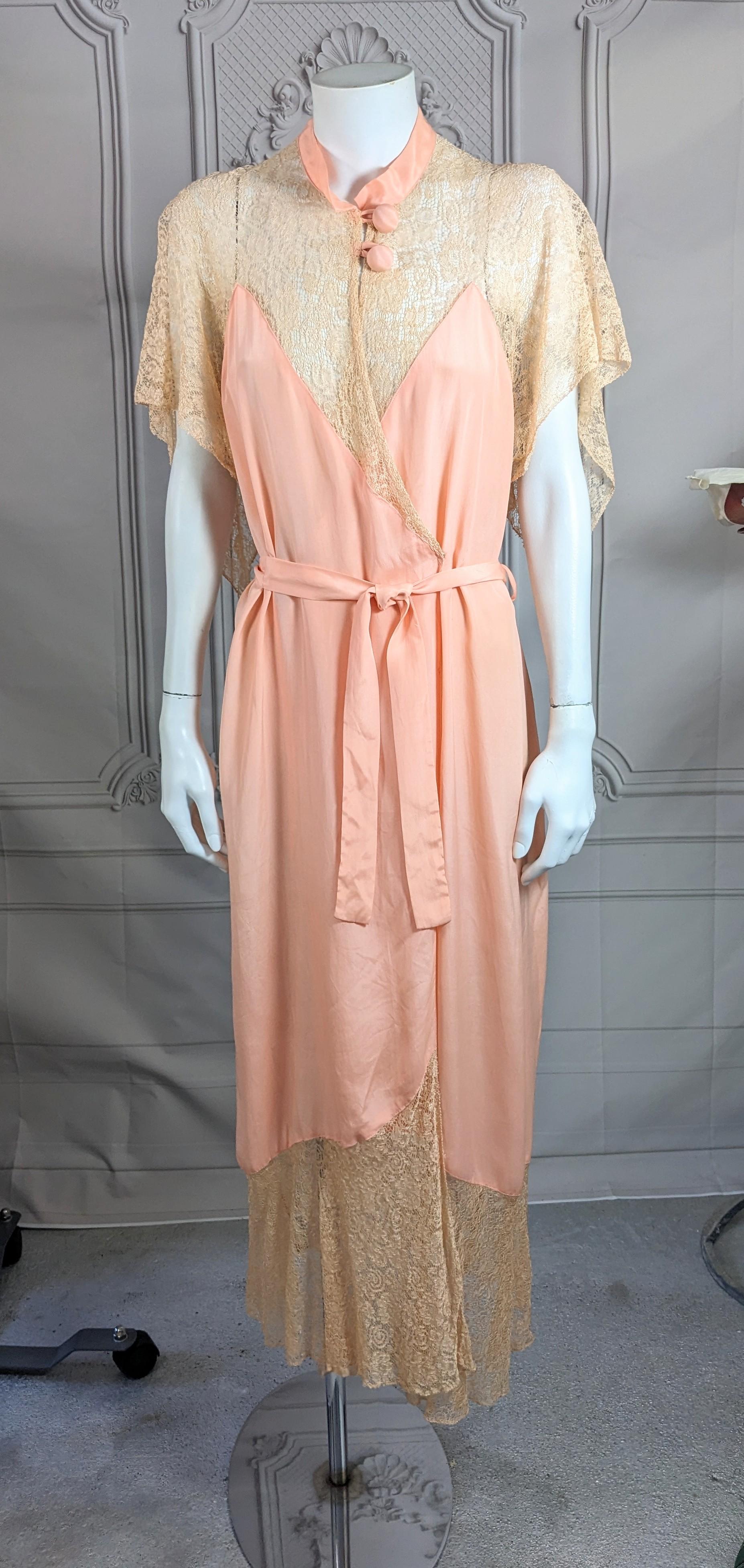 Art Deco negligee wrap dress of pink silk crepe with deep hem, capelet sleeves and back of sheer floral patterned beige colored lace. Unusual Mandarin collar detail with two large covered buttons. Excellent Condition. 1930's USA.
L 51