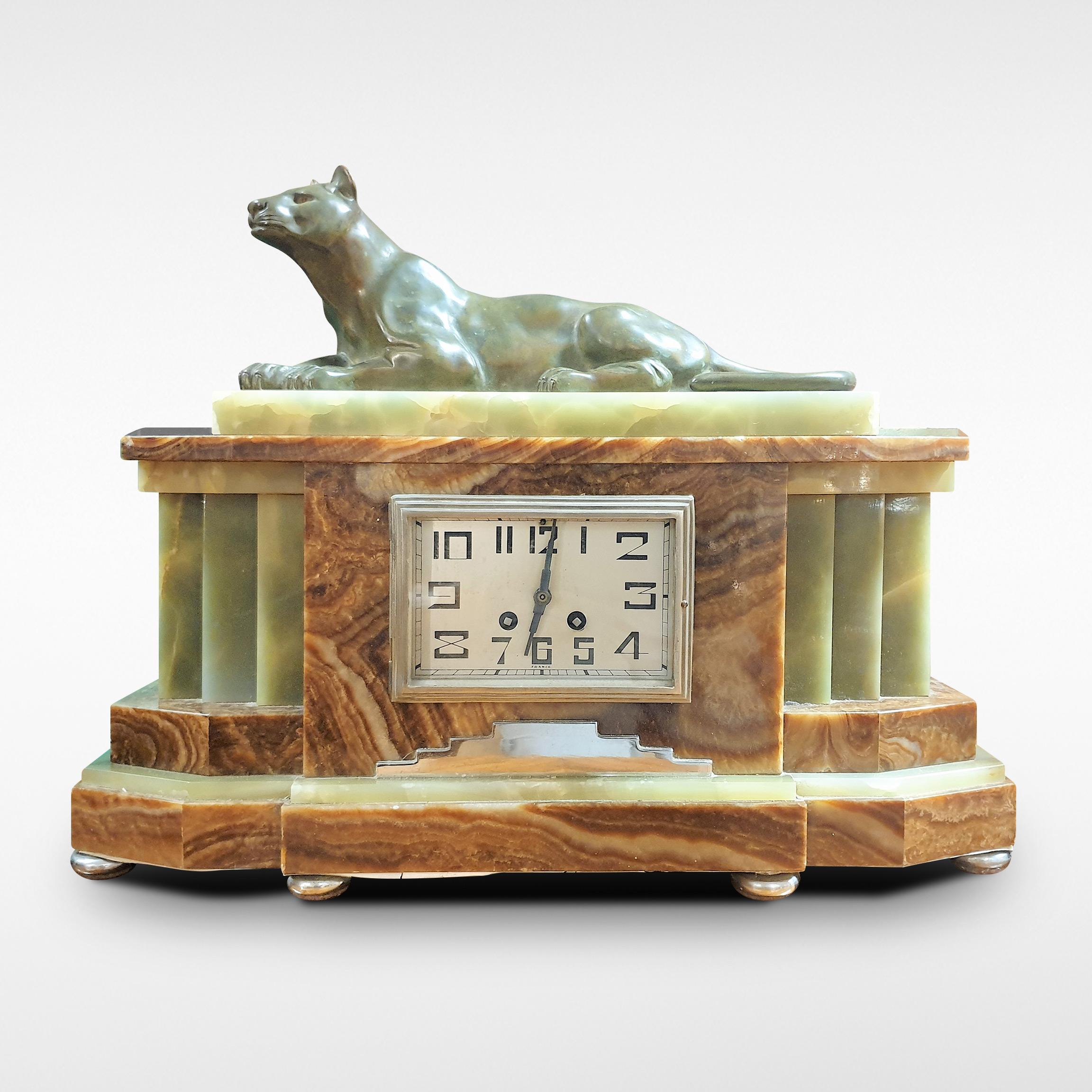 Art Deco marble mantel clock with garnitures surmounted by seated Panther, French, circa 1935-1955.