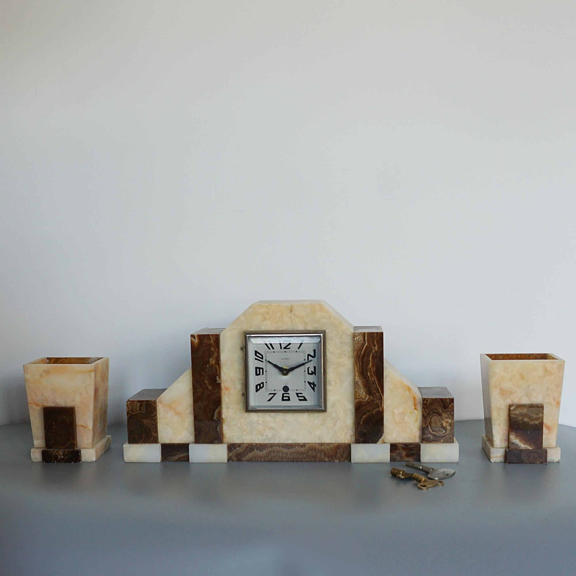 An Art Deco marble mantel clock with matching garnitures. Stylised face, with 8 day movement converted to battery power.

Dimensions: H 22cm W 45cm D 9cm, Garnitures: H 13.5cm W 10cm D 8cm

Origin: French

Date: Circa 1935

Item Number: 2108245