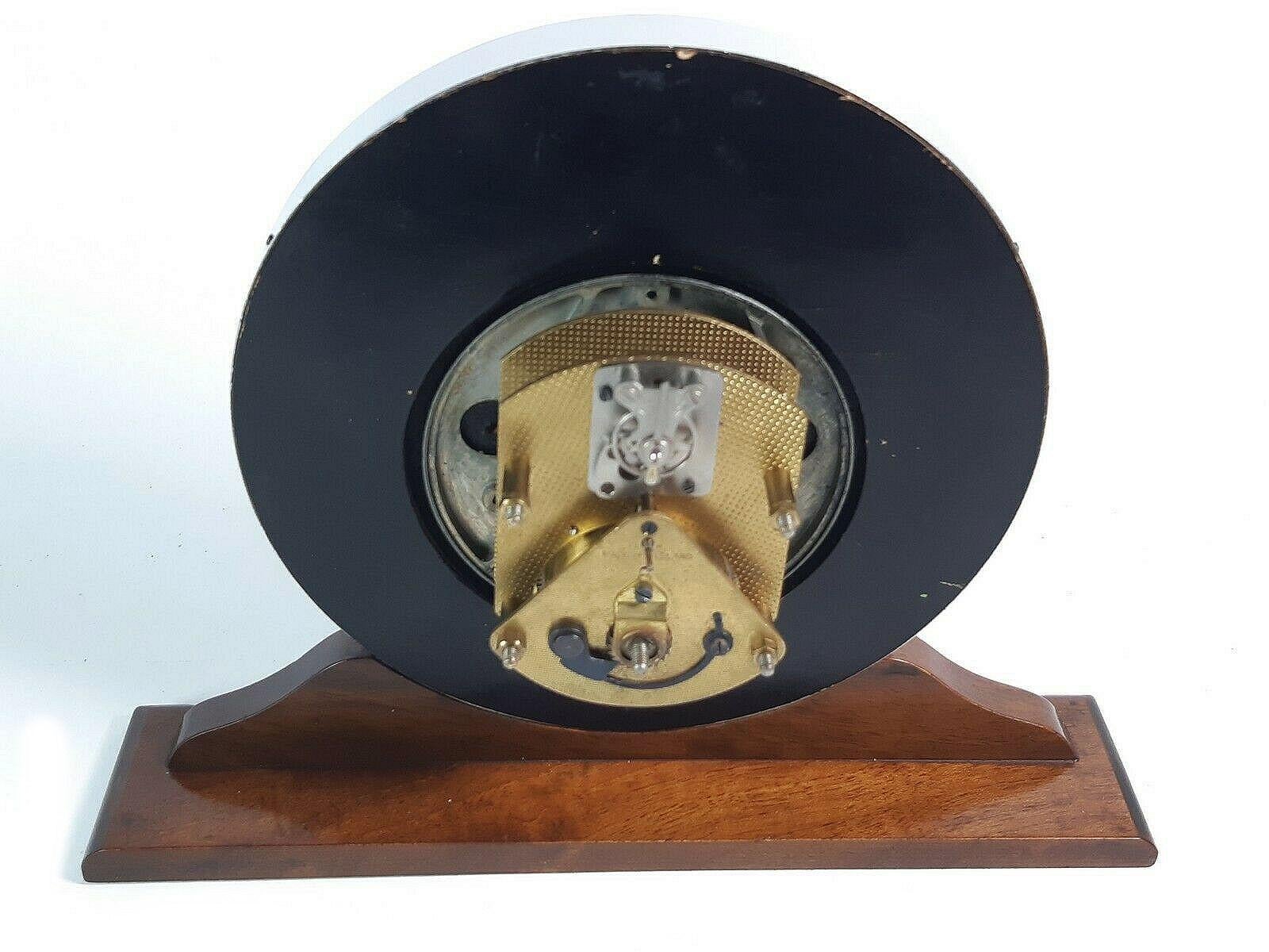 For your consideration is this super stylish Art Deco Wood and Glass Mantle Clock With Working Original Movement, dating to 1938. Round wood case on polished wood base. The domed glass is held in place within a chromed rim. The clockwork movement is