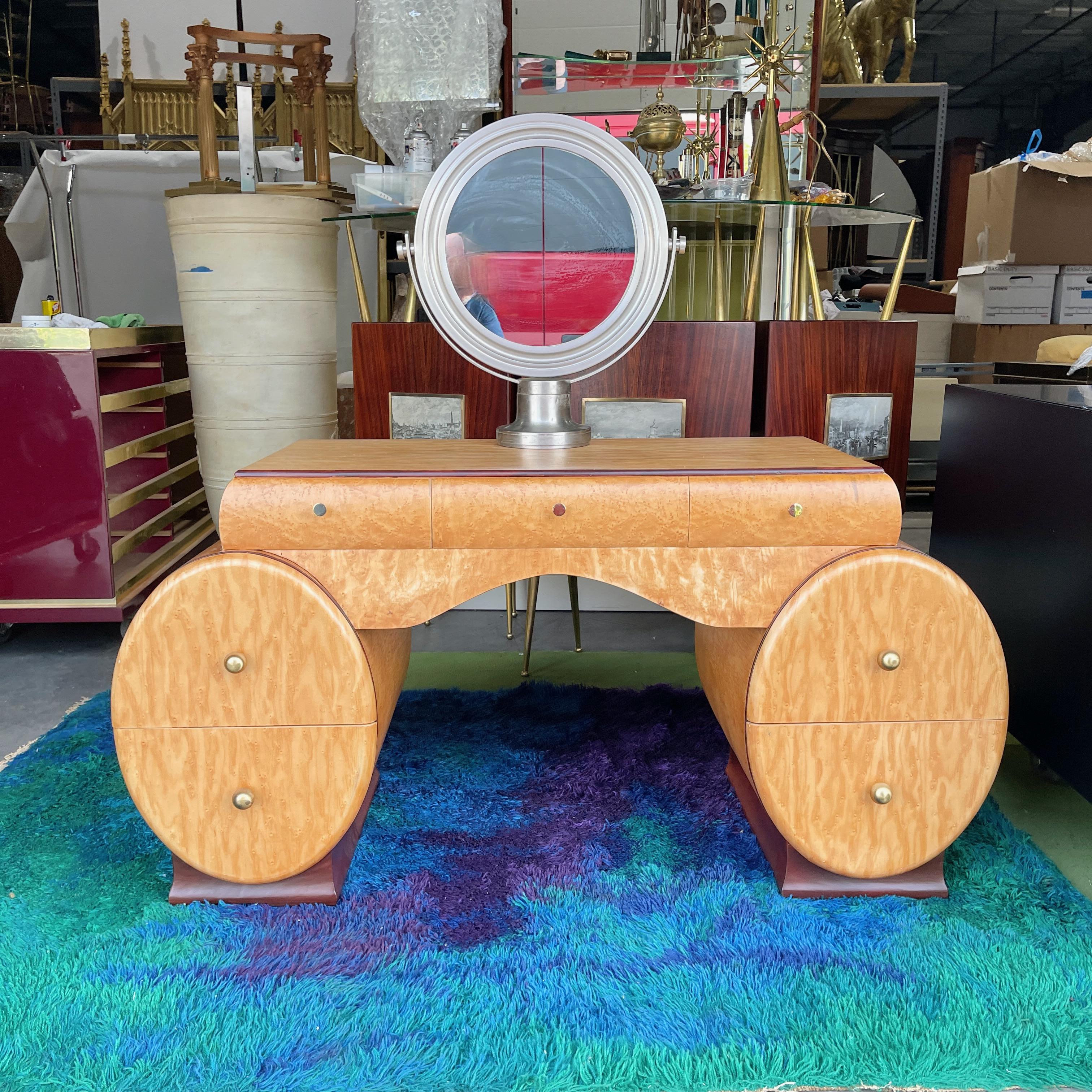 Comodino Art Deco americano in impiallacciatura di acero figurato.
Un design insolito con un piano rettangolare incassato con tre cassetti sopra una coppia di casse ovali con due cassetti ciascuna. 
Le casse poggiano su basi a zoccolo in mogano a