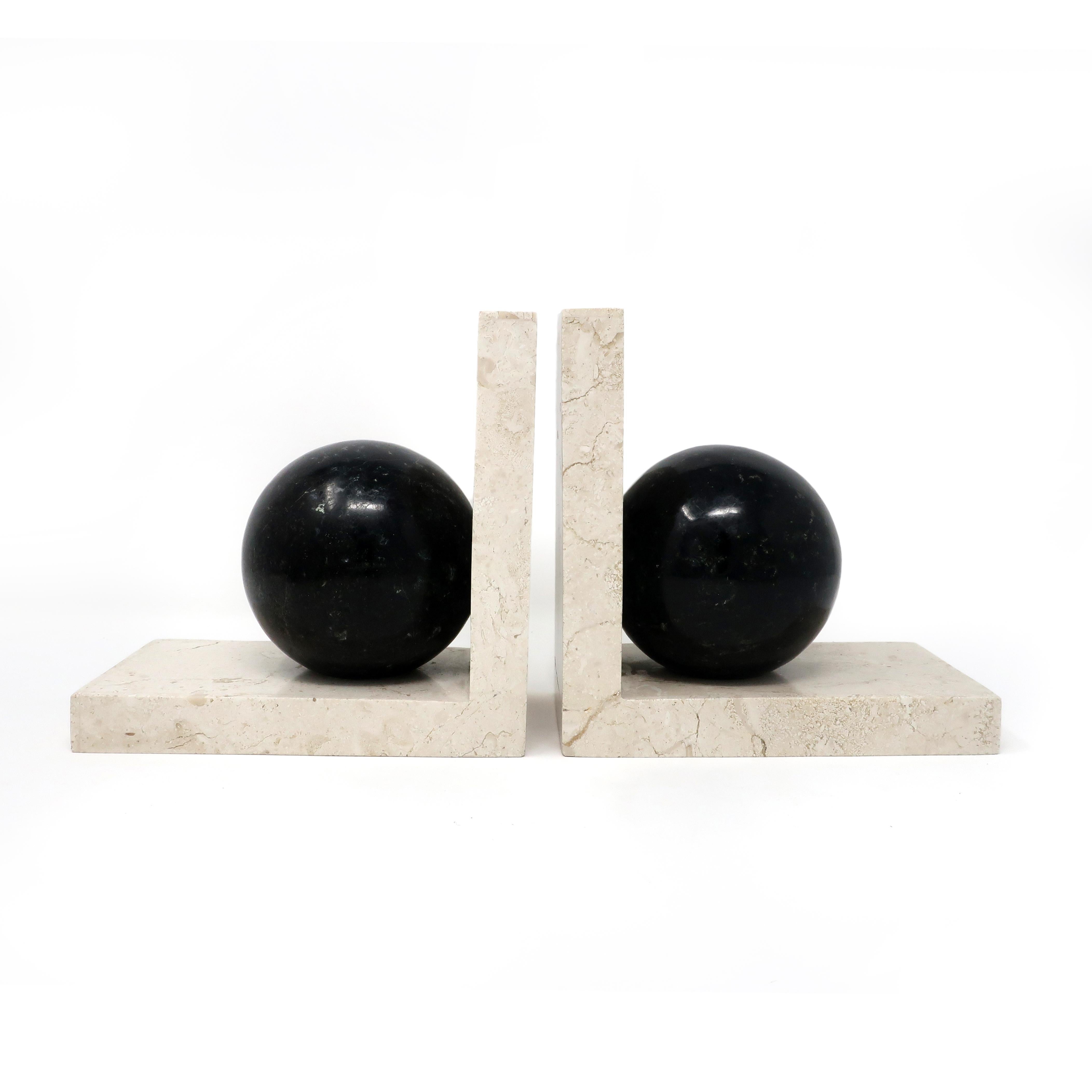 A pair of marble Art Deco bookends by Renoir with a perfect right angle in light stone holding a dark stone sphere. In good vintage condition with wear consistent with age and use. Each piece has a maker’s sticker on underside.

Measures: 7