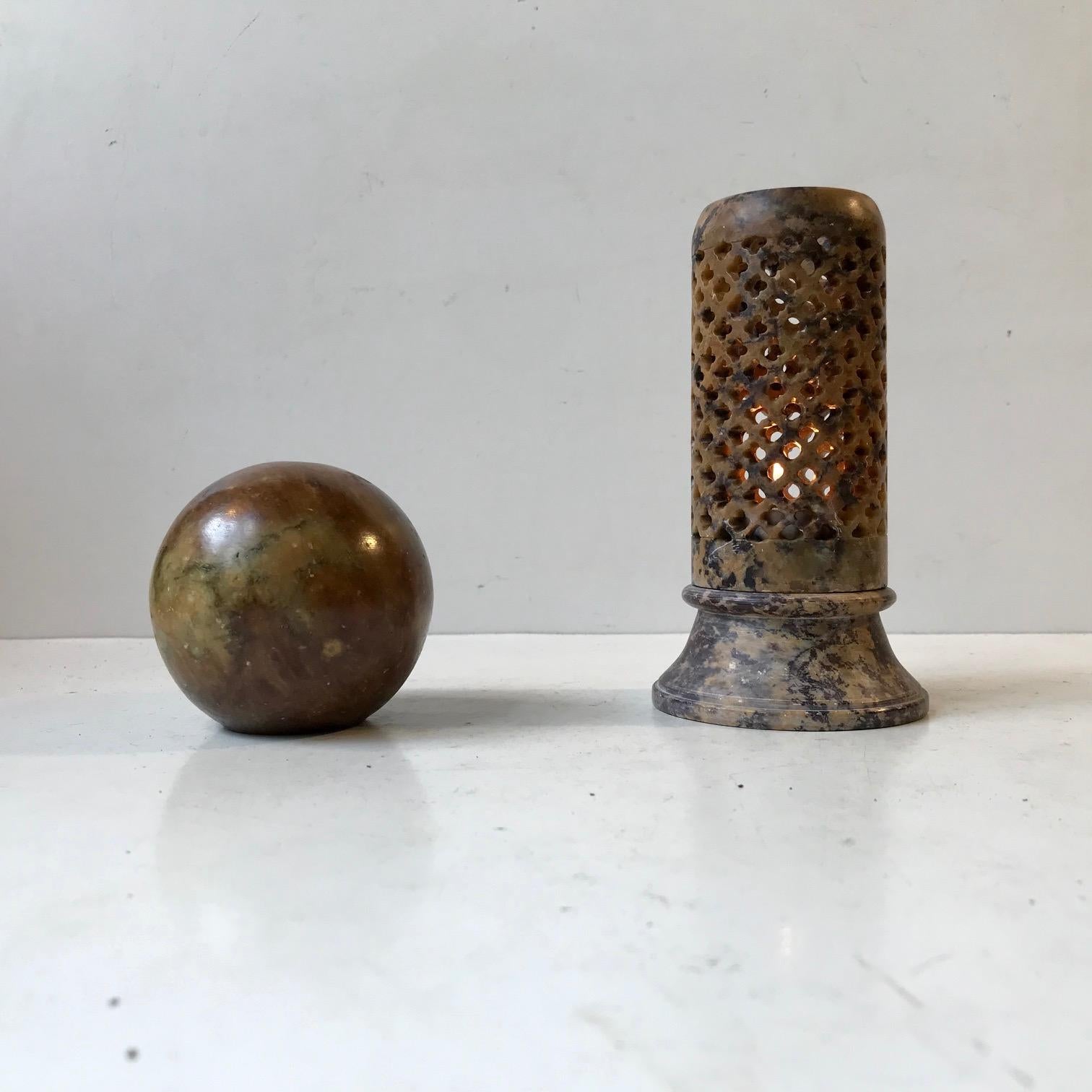 Decorative set in textured brown marble consisting of a paperweight sphere and a perforated candleholder for a tea- or small bloc light candle. The set was made in Scandinavia during the 1930s. Measurements: H: 14/6.5 cm.