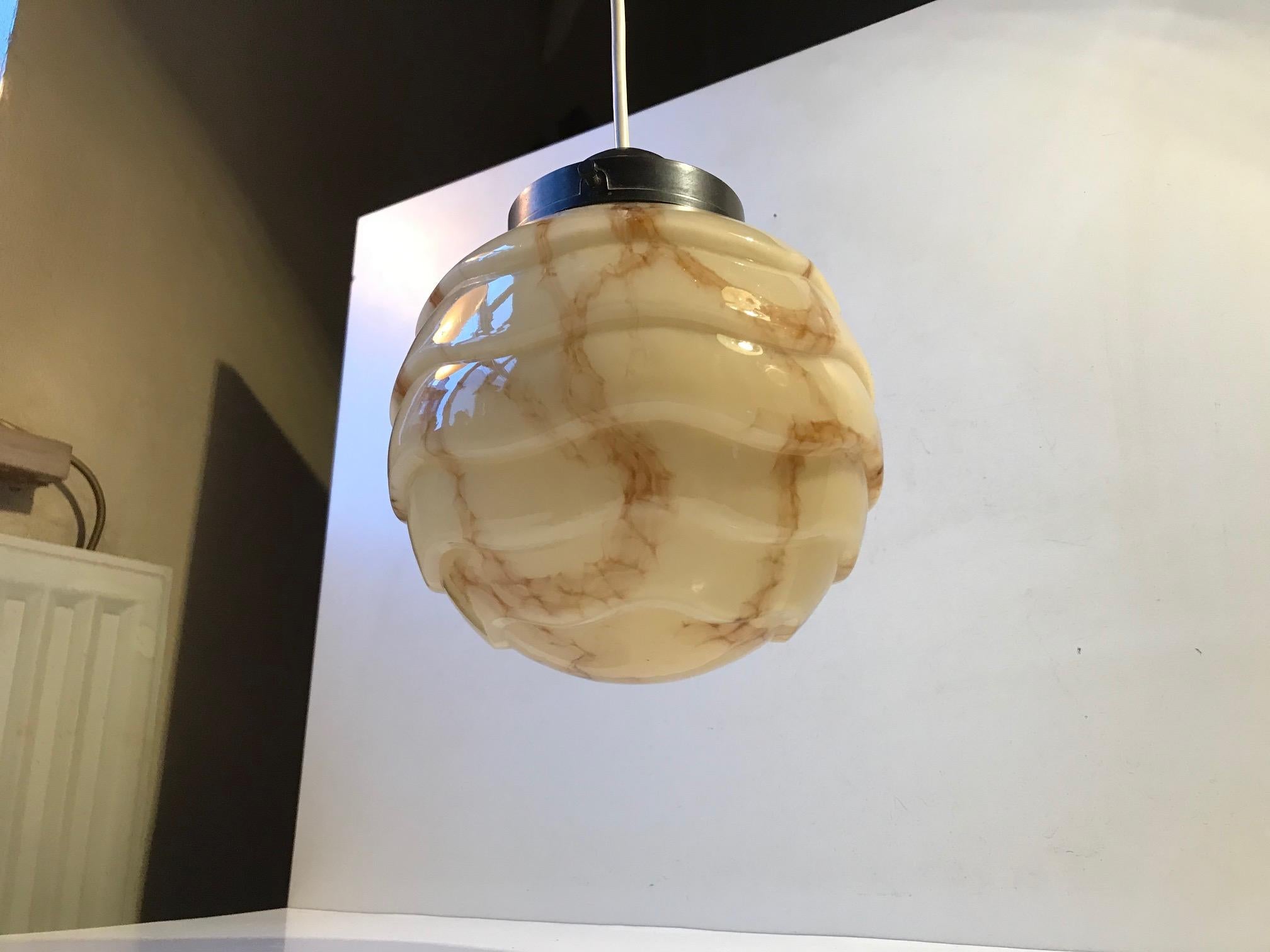 A wavy and marbled opaline glass pendant lamp with bakelite socket. Manufactured in Denmark during the 1920s or 1930s. New wire has been applied.