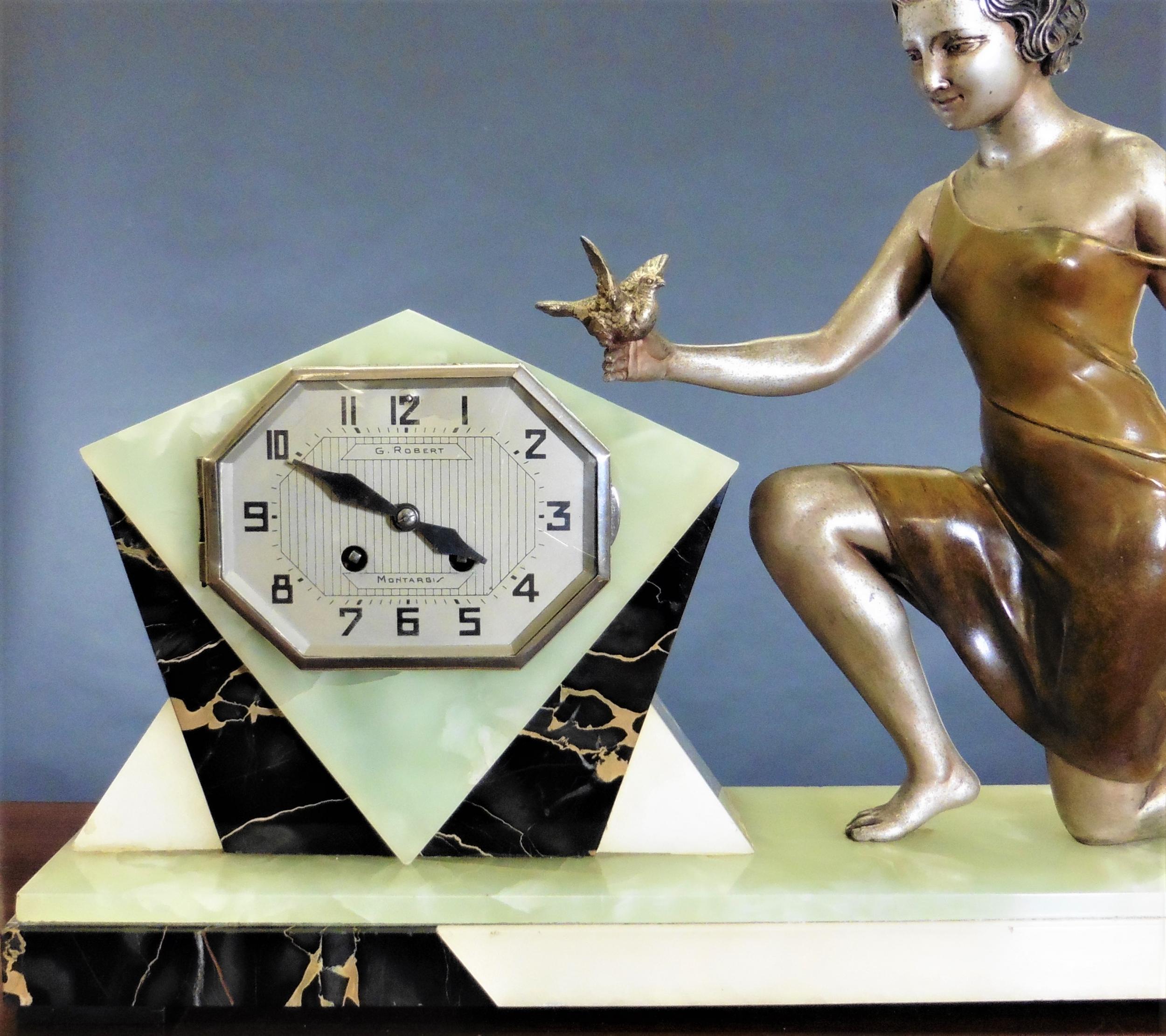 Art Deco mantel clock



Art Deco mantel clock standing on a black, green and cream marble base featuring a maiden training a dove.


Chrome bezel with convex glass opening to a silvered decorated dial with Art Deco style numerals and
