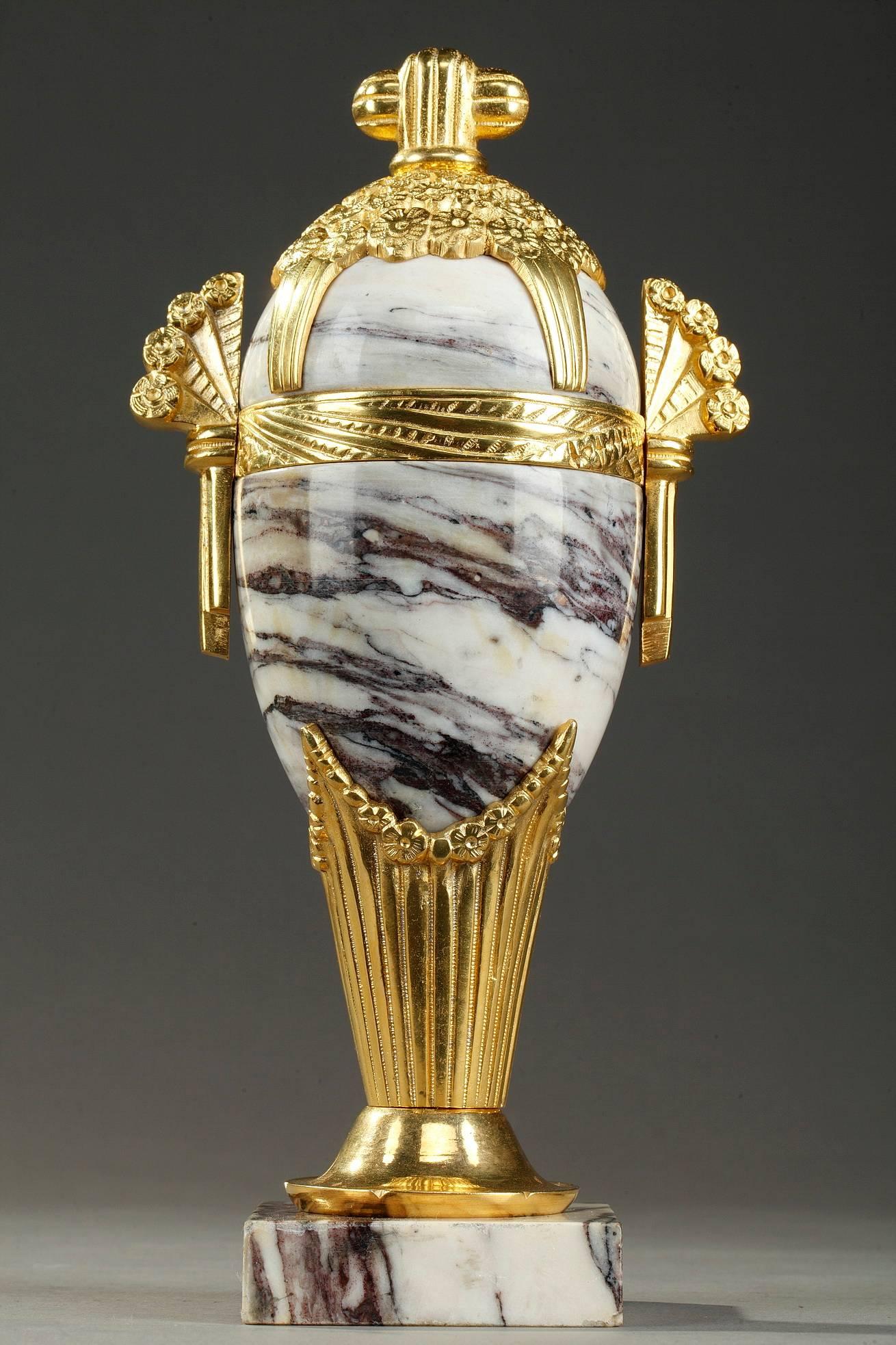 Pair of Art Deco vases crafted of white marble and gilt bronze, finely chiseled with stylized draperies and garlands of flowers. Two bunches of flowers form the handles, and four others adorn the lid.


circa 1930
Dimensions: W 4.9 in - D 3.1in