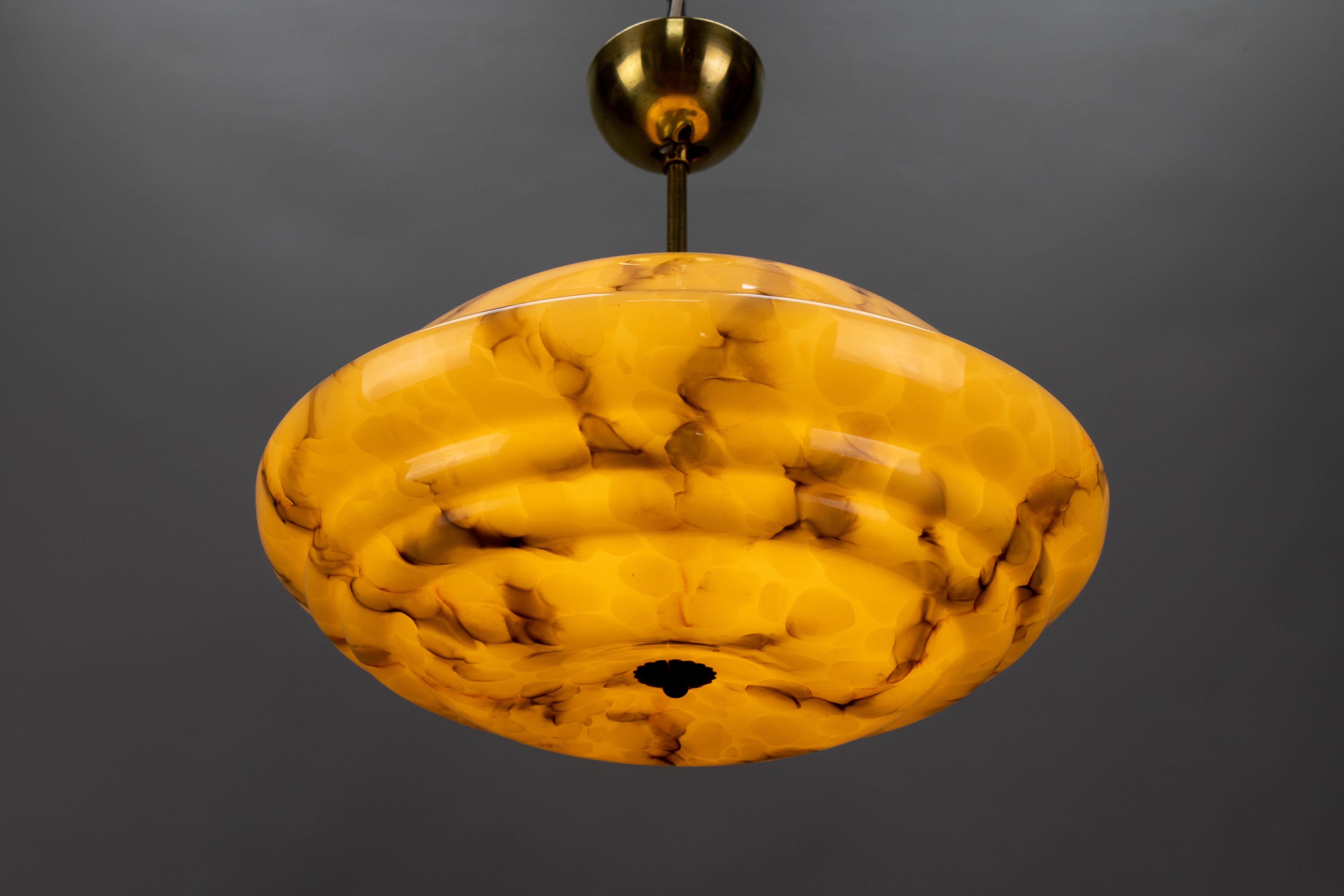 Art Deco Marbled Amber and Brown Glass and Brass Pendant Light, Germany, 1930s

A striking Art Deco pendant light from 1930s Germany, featuring a richly marbled amber and brown glass shade paired with brass fittings. The tiered, dome-shaped glass