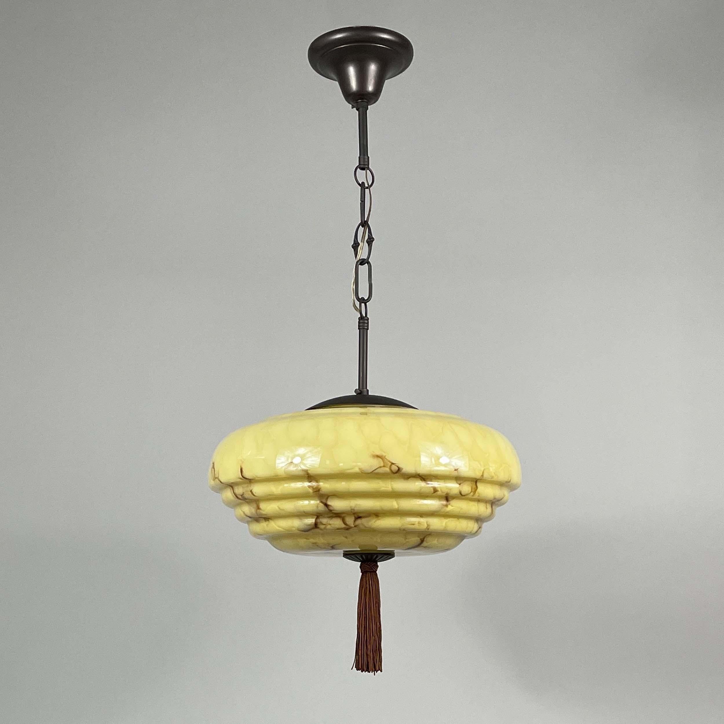 This elegant Art Deco pendant was designed and manufactured in Germany during the Bauhaus Period in the 1920s to 1930s.

It features a dark cream / sand colored opaline glass lampshade with brown marbled decor, bronzed / burnished metal hardware and