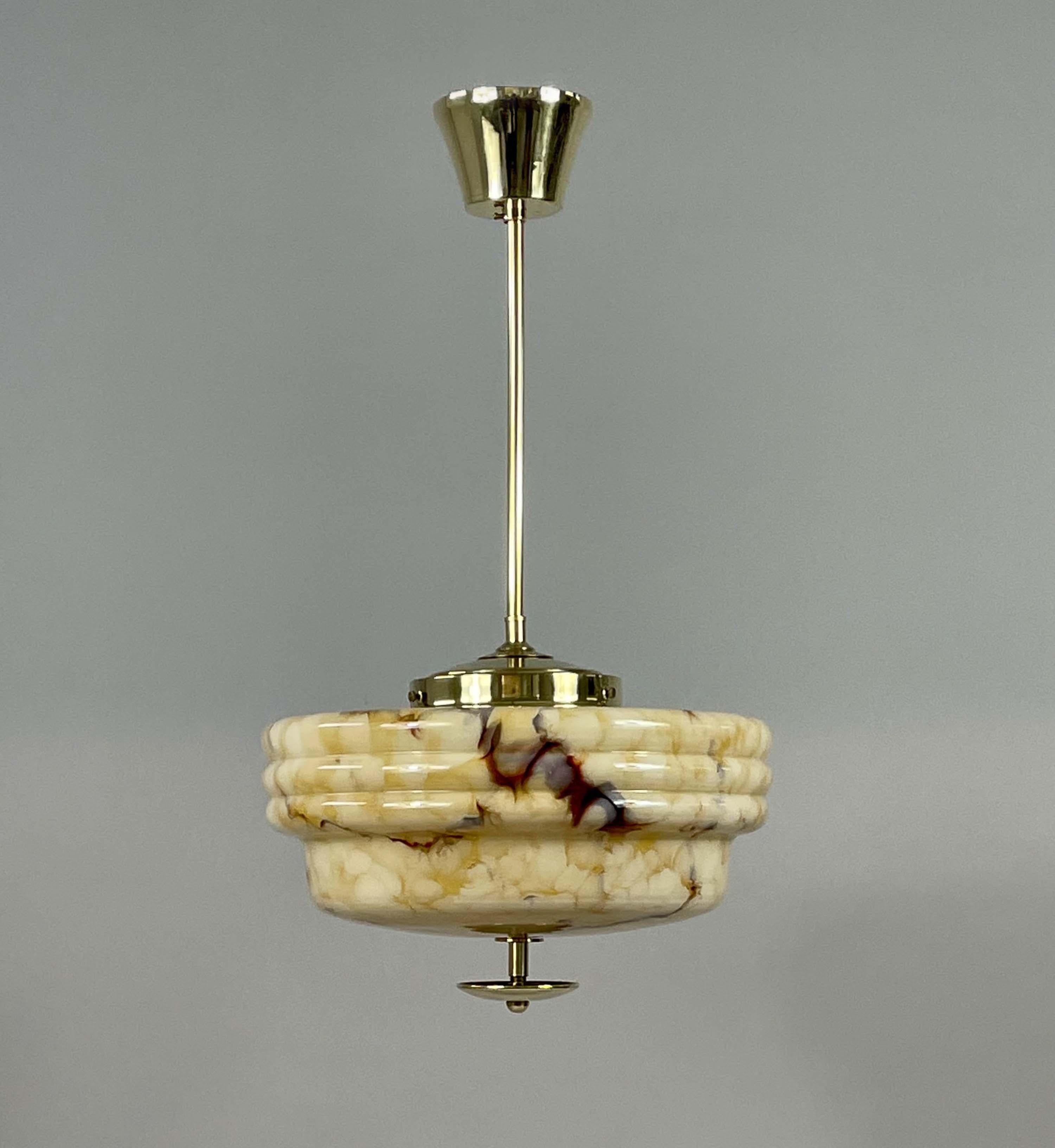 Este semiempotrable minimalista Art Decó se diseñó y fabricó en Alemania en la década de 1930, durante la época de la Bauhaus. Presenta una pantalla redondeada y herrajes de latón. La pantalla está hecha de vidrio opalino jaspeado de color arena,