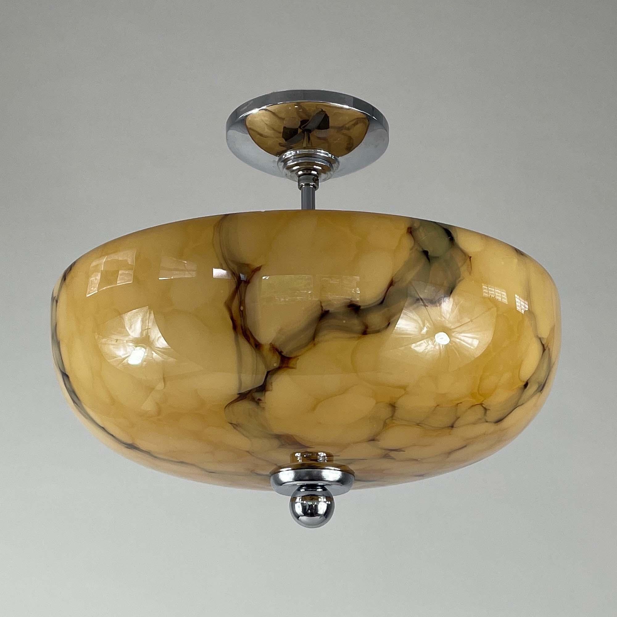 This semi flush mount was designed and manufactured in Germany in the 1930s during the Bauhaus era. It features a rounded bowl-shaped shade and chrome hardware. The shade is made of sand, beige and brown colored marbled opaline glass, with a
