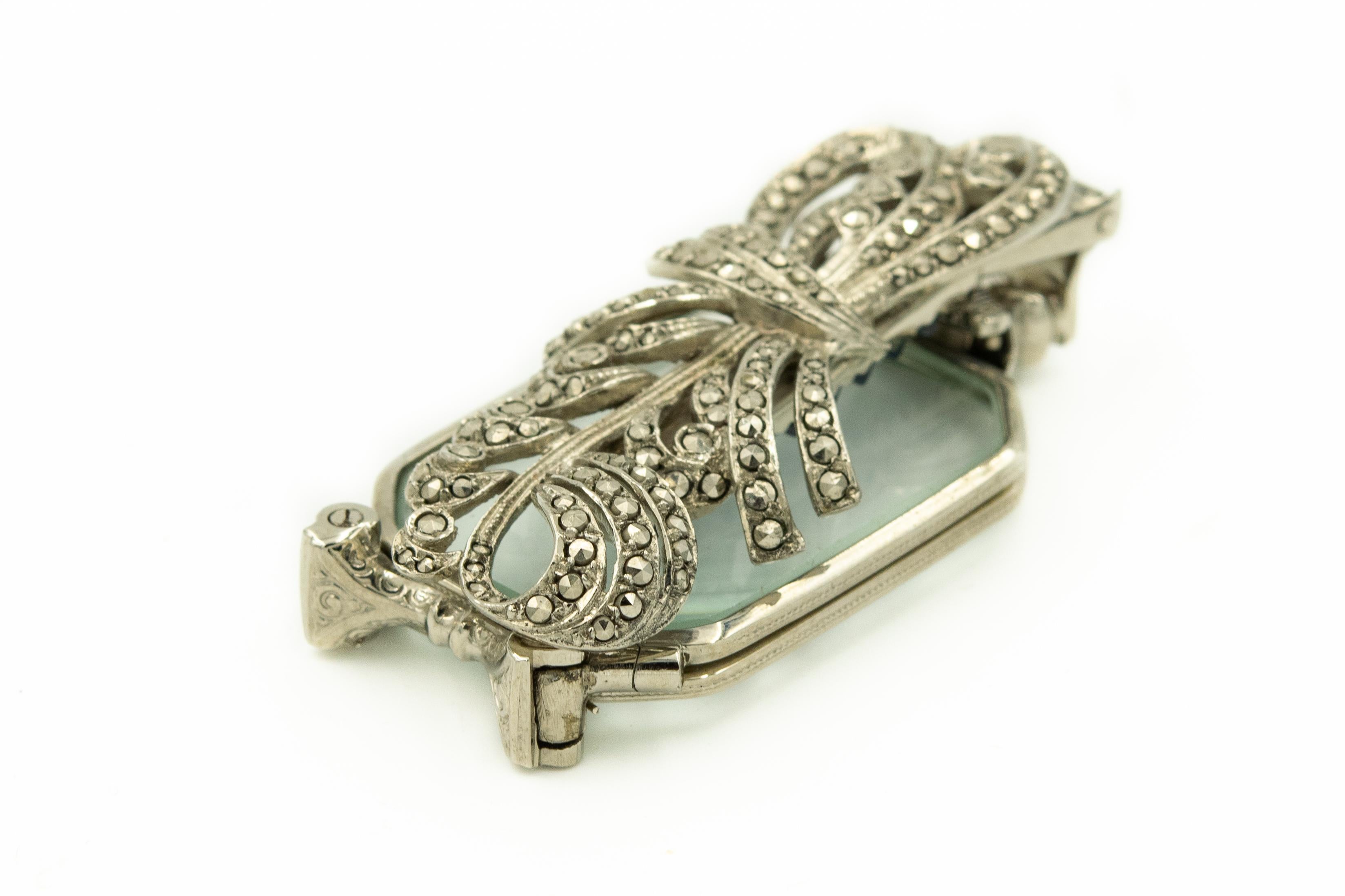 Elegant Antique silver & marcasite folding lorgnette.  It features a bow motif with curling scrolls.  The lorgnette folds neatly and can be worn as a clip brooch.  It measures 2.26