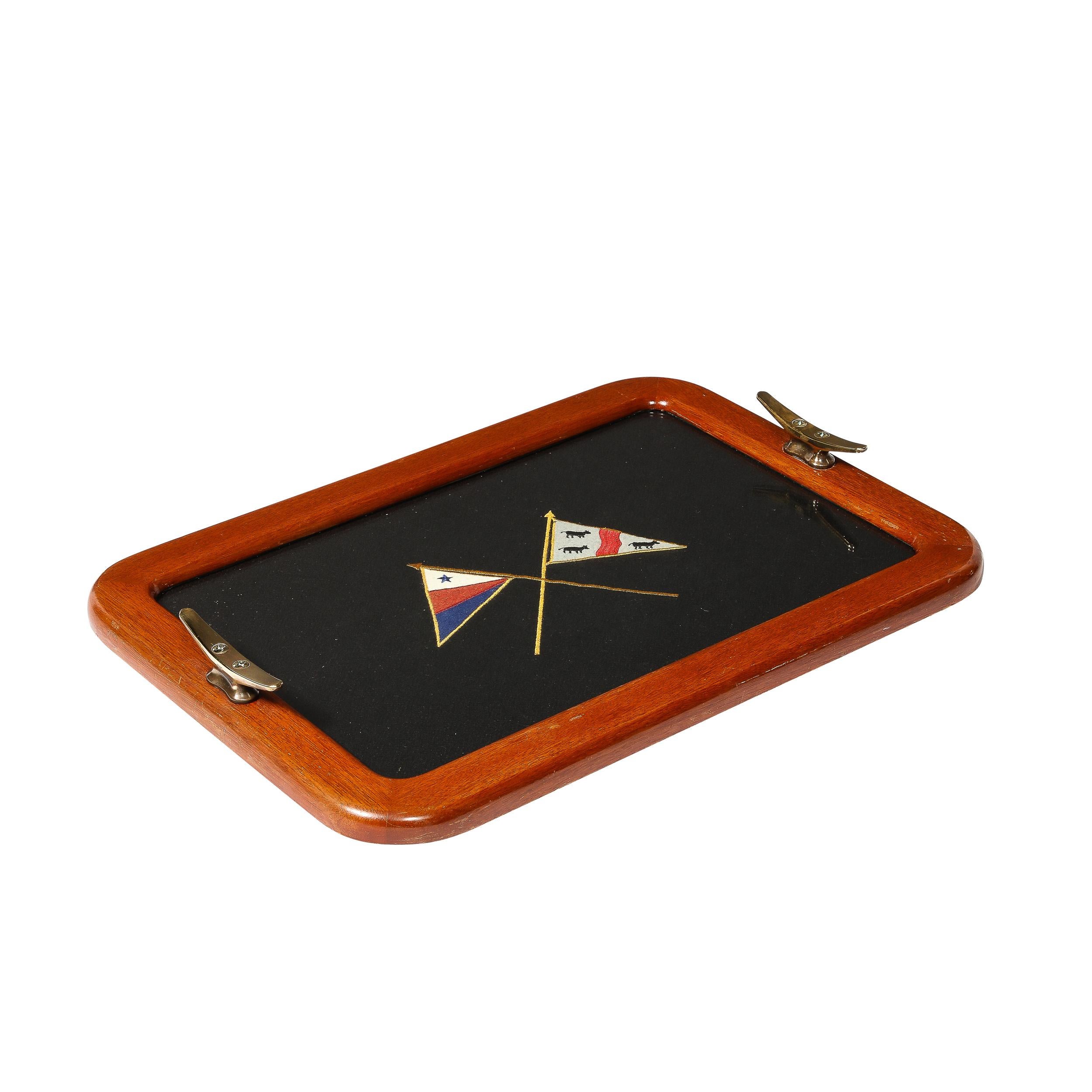 Ce plateau de service provient des États-Unis vers 1940. Il est bordé de noyer avec des broderies encadrées et des poignées en laiton. Le cadre est doucement arrondi dans les coins avec des poignées surélevées de chaque côté, le tissu noir en bel