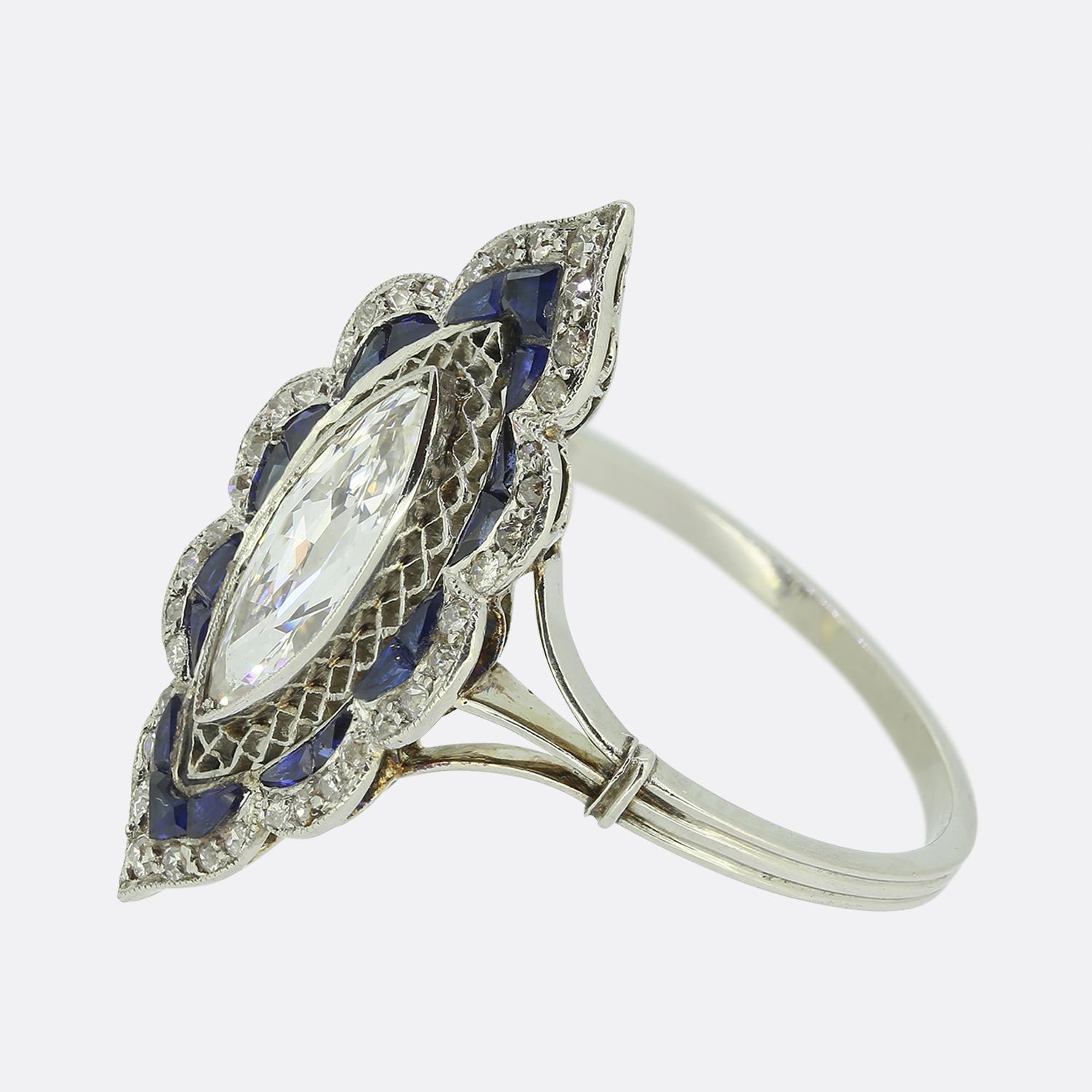 Here we have a marvellous navette ring crafted at a time when the Art Deco style was at the height of world design. A single bright white marquise-cut diamond commands attention at the centre. This principal stone sits slightly risen atop a lattice