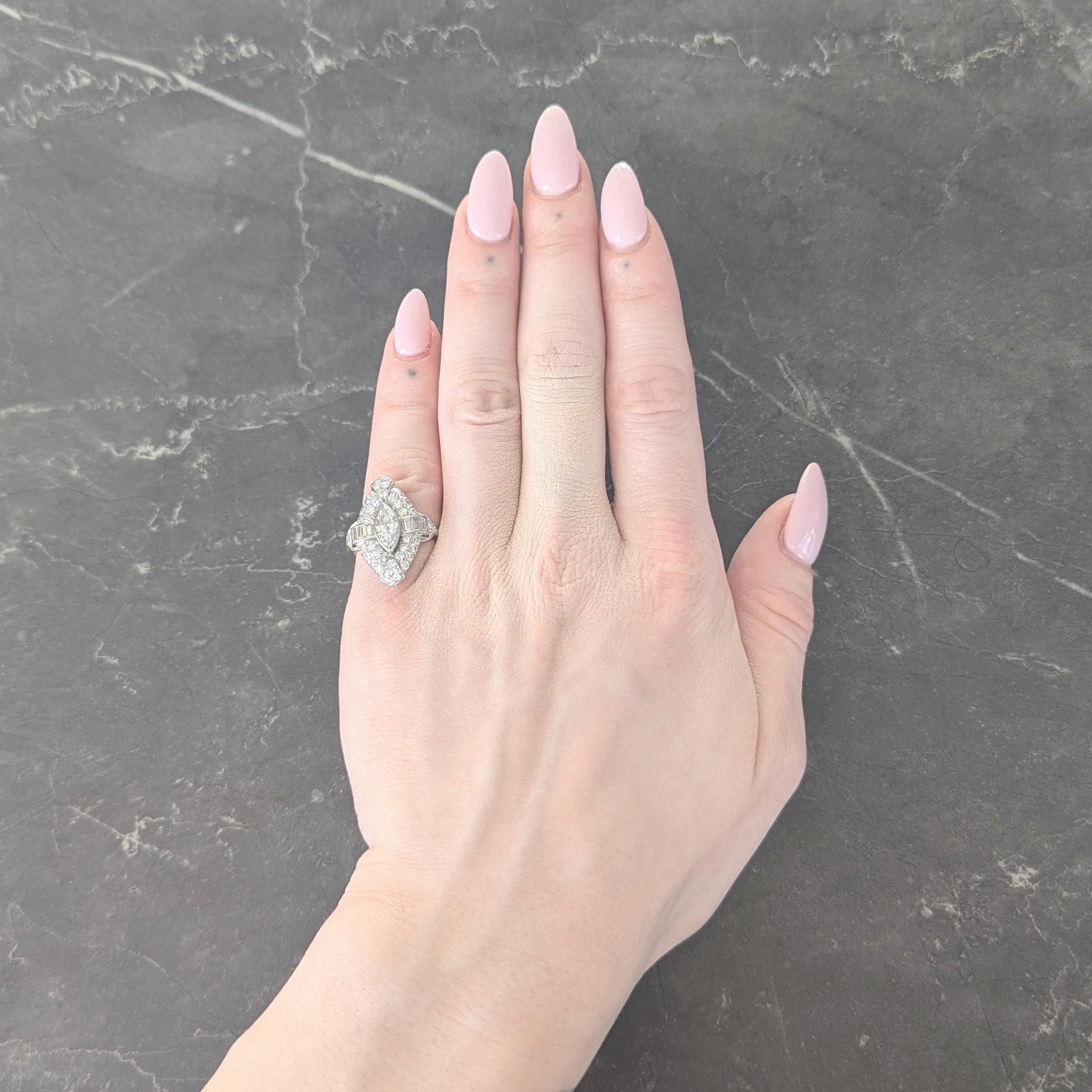 Centering a marquise cut diamond weighing approximately 0.54 carat - H color with VS2 clarity
Bezel set with a pierced navette shaped halo surround of bead set old European cut diamonds
Weighing approximately 1.18 carats total - G/H color with VS2