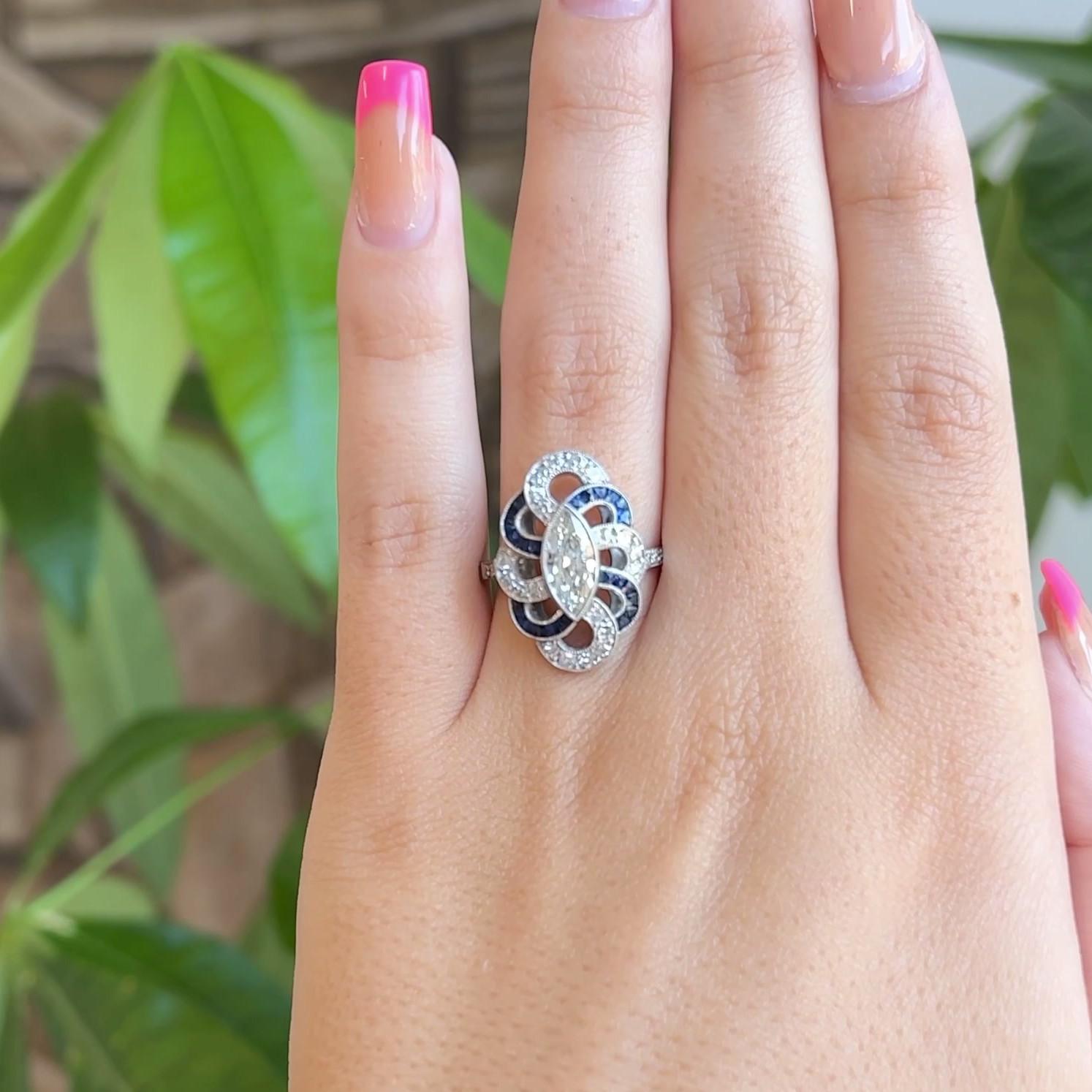 Eine Art Deco inspiriert Marquise Cut Diamond Sapphire Platinum Ring. Mit einem Diamanten im Marquise-Schliff von 0,72 Karat, Farbe I, Reinheit SI. Akzentuiert durch 24 Saphire im Kaliberschliff mit einem Gesamtgewicht von ca. 1,00 Karat und 26