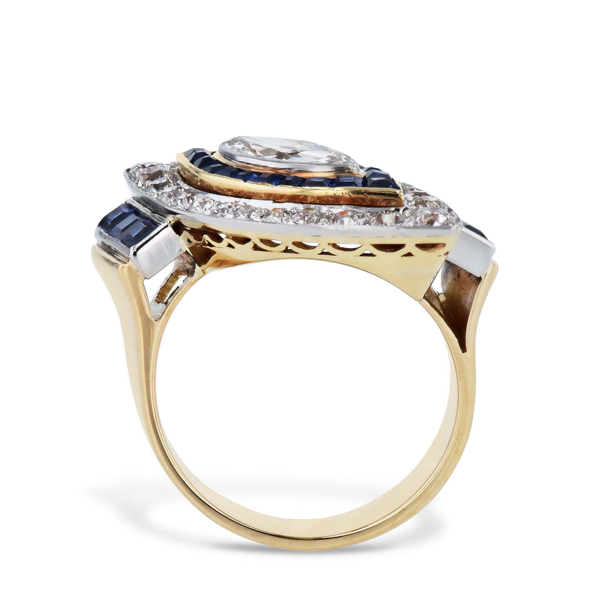 This Art Deco Marquise Diamond Sapphire Estate Ring sparkles with grandeur! Crafted from Platinum and 18kt yellow Gold, one Marquise cut diamond surrounded by 24 Old European cut Diamonds (approx. 0.70ct TW), 20 Calibre cut sapphires (approx. 0.40ct