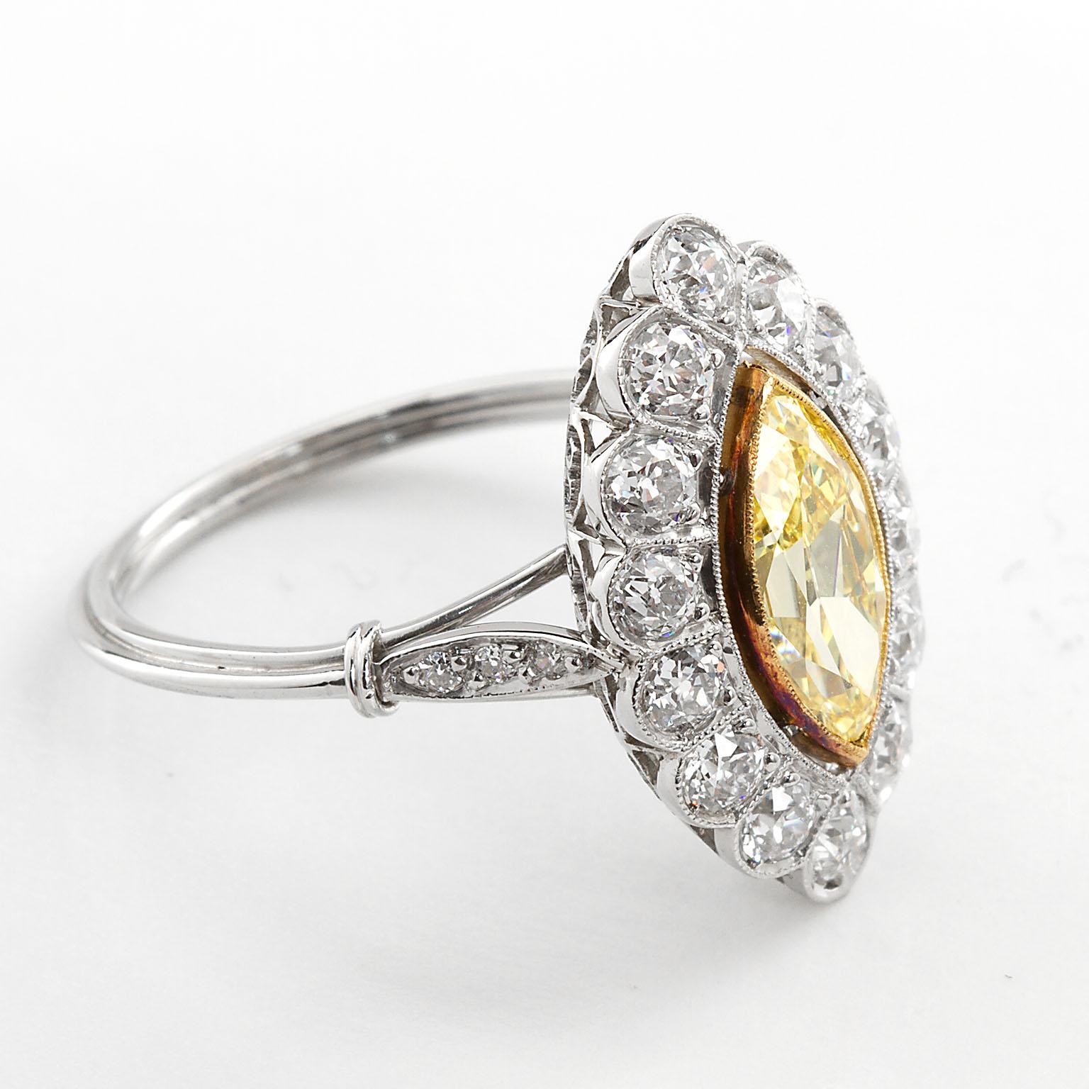 An original Art Deco period cluster ring of white gold and yellow gold set with a 1.16 carat Fancy Intense Yellow color Marquise shape diamond with Internally Flawless clarity characteristics according to the accompanying GIA Diamond Report.
The
