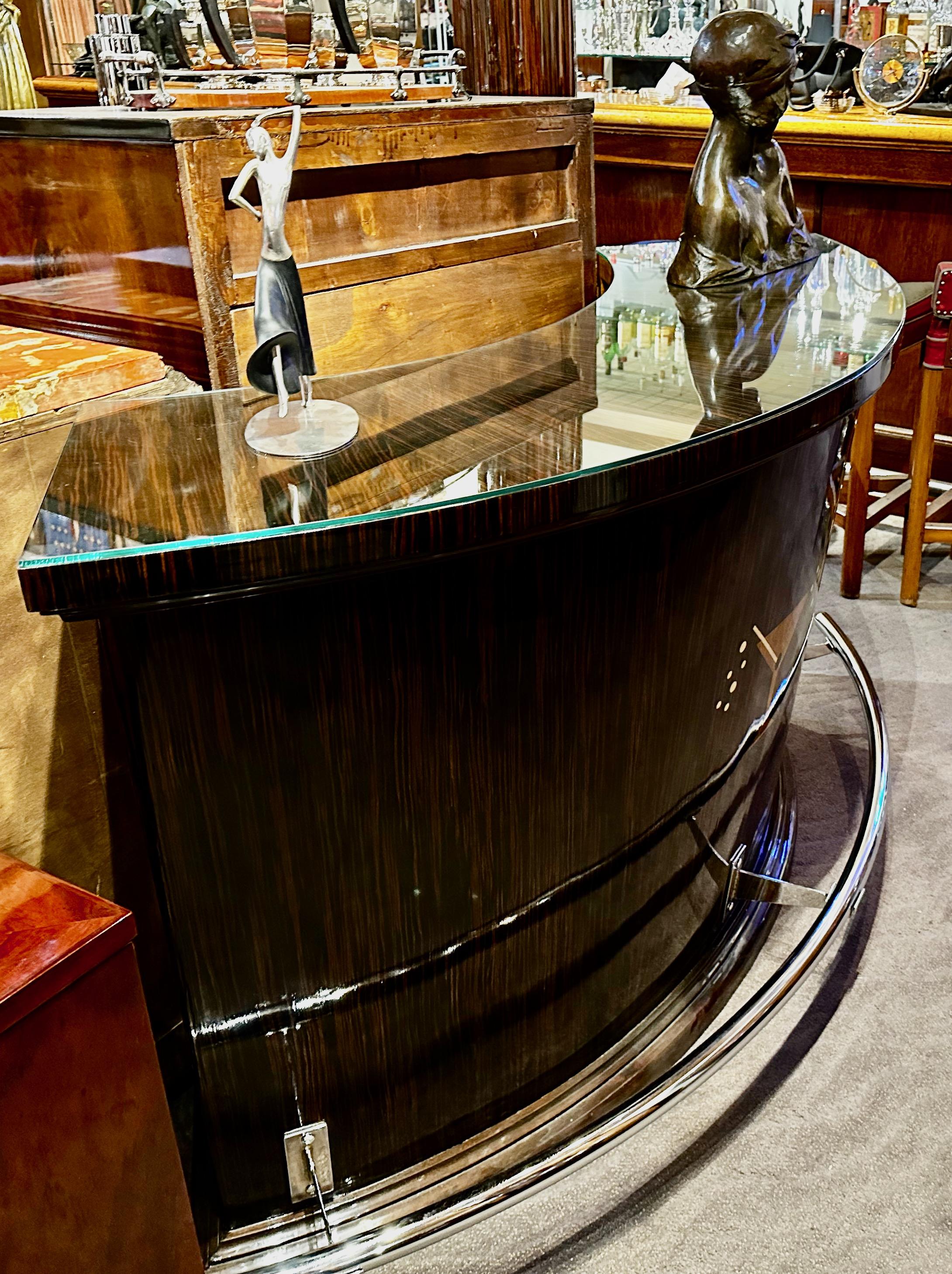 Le bar à Martini Art Deco en bois exotique de Macassar est une exclusivité de la Collectional Art Deco. À la demande générale, nous l'avons réintroduit et y avons ajouté un rail de pied chromé épuré. Une taille généreuse pour accueillir vos invités