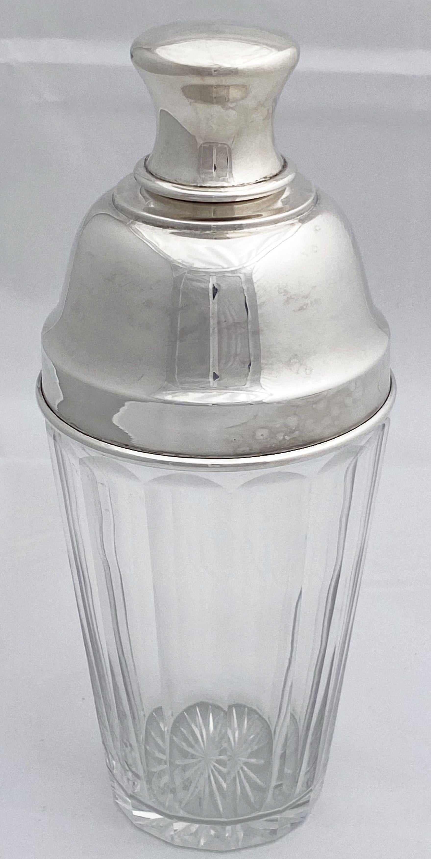 A vintage English cocktail shaker of fine plate silver and cut glass from the Art Deco period, c.1930, featuring a stylish cap and faceted glass body with internal ice strainer.